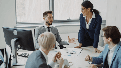 Two professionals in a business meeting discussing strategy at a conference table.