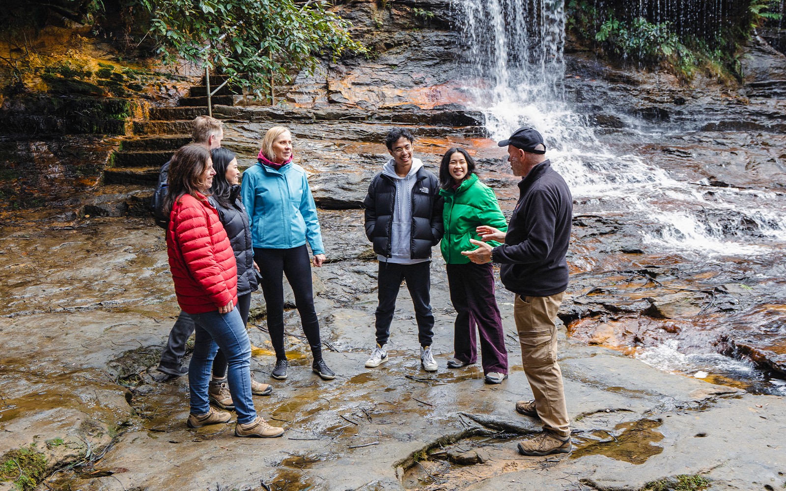 Guide leading group near waterfalls in Blue Mountains, Australia.