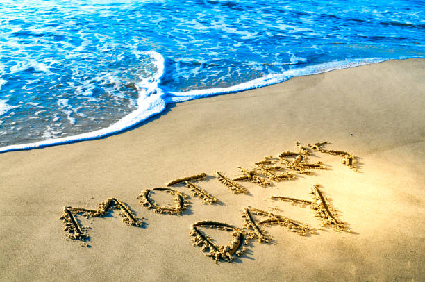 "Mother’s Day” written in the sand with ocean waves nearby—perfect for highlighting Avo Limo’s luxury car service for treating Mom to a relaxing, elegant day out in Denver.