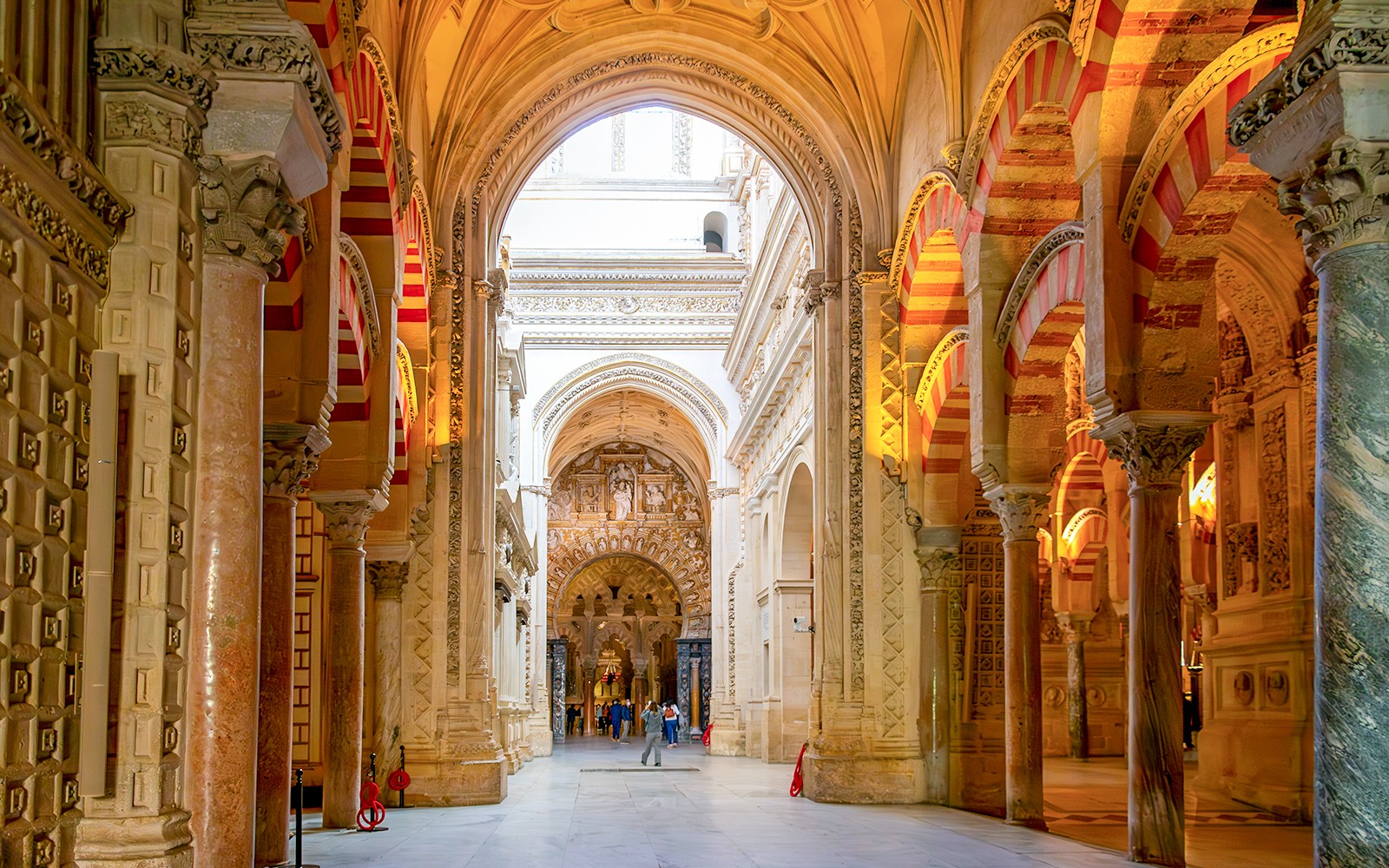 Visitantes explorando los arcos y columnas dentro de la Mezquita-Catedral de Córdoba.
