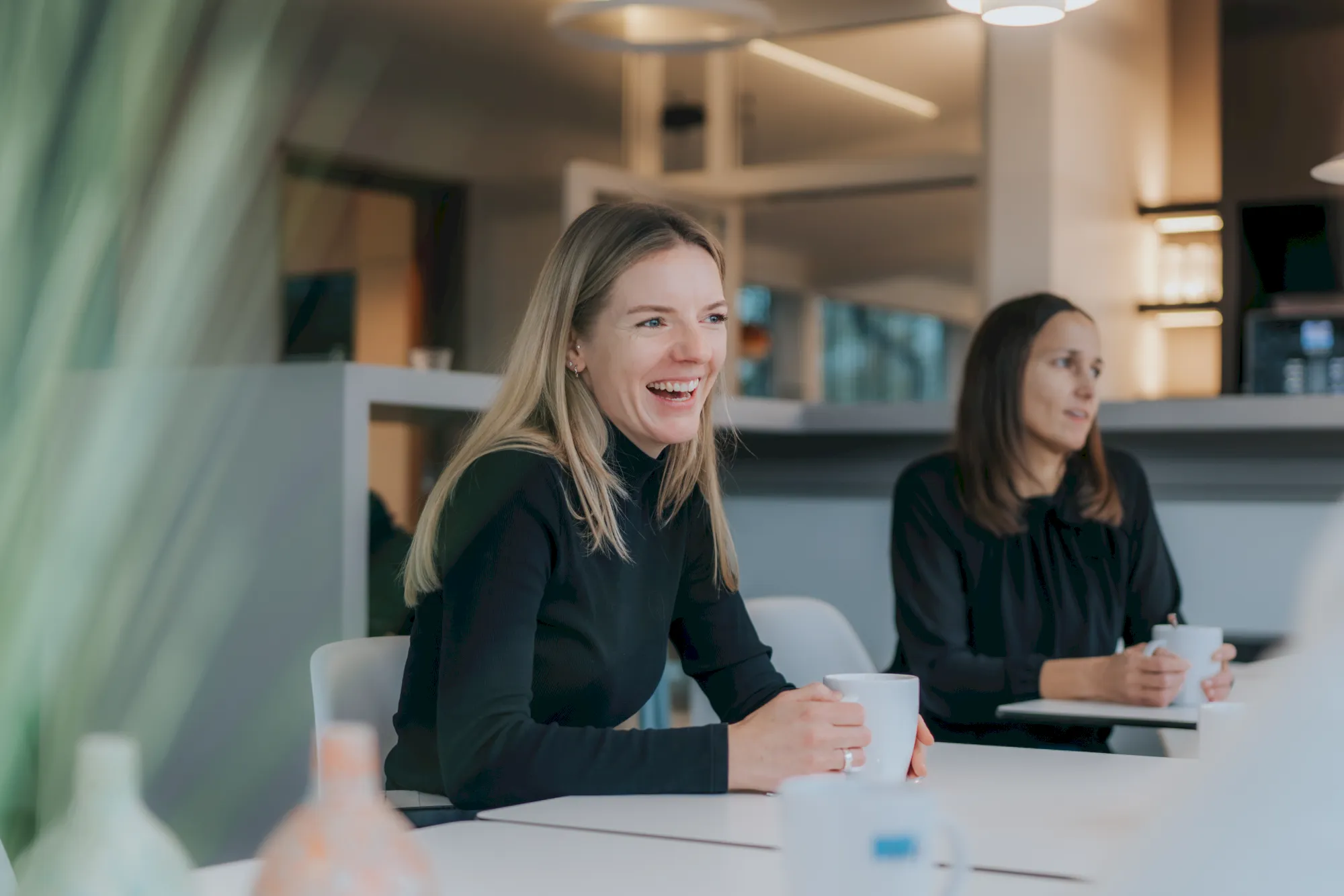 Fröhliche Frauen lachen bei einem Meeting, Teamarbeit