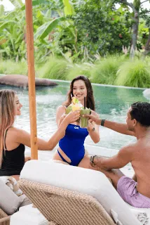 A sparkly pink ornament hangs on a christmas tree.