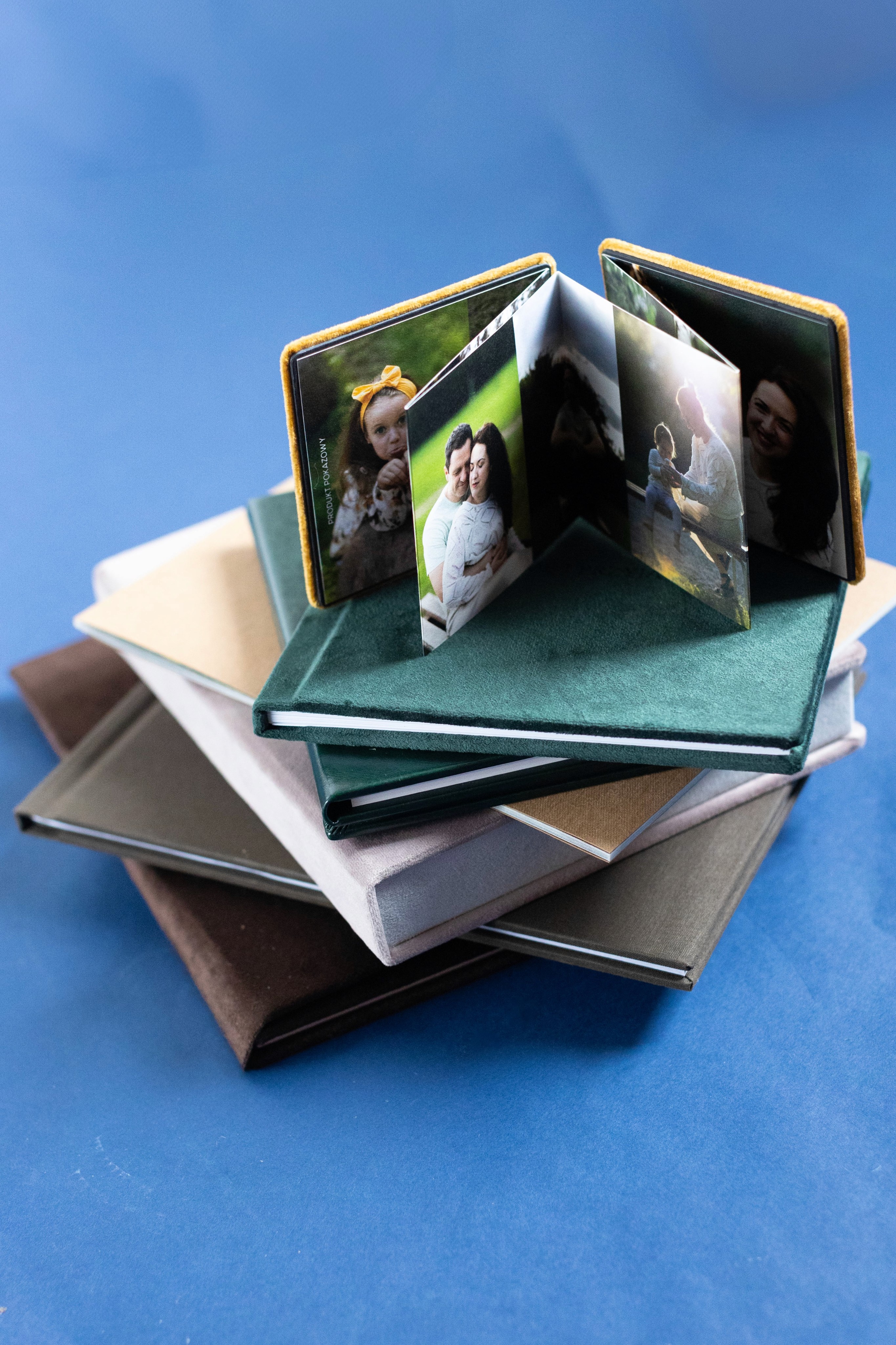 Stos albumów fotograficznych z jedym otwartym na górze
