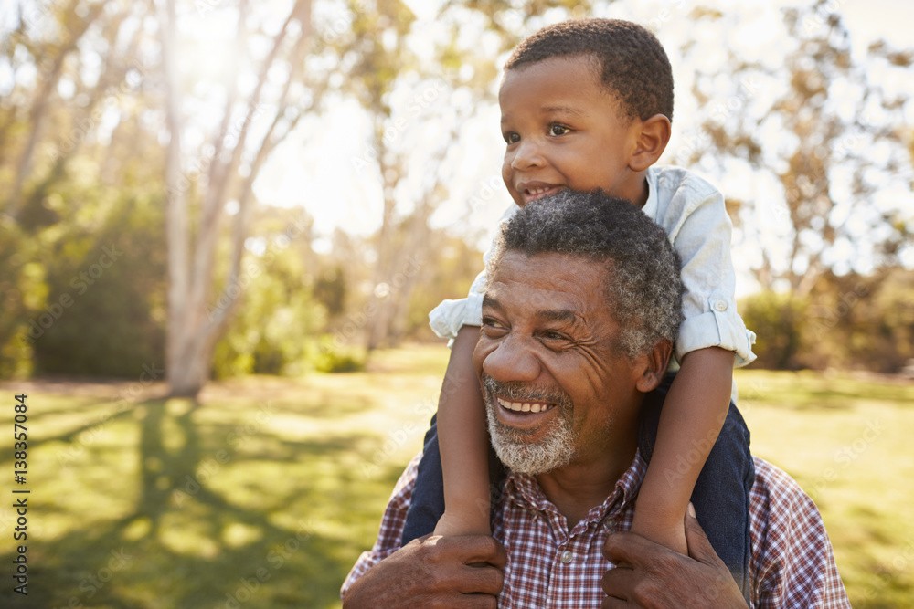A sunlit portrait of a woman in elegant summer attire, wearing a striped headscarf and gold hoop earrings