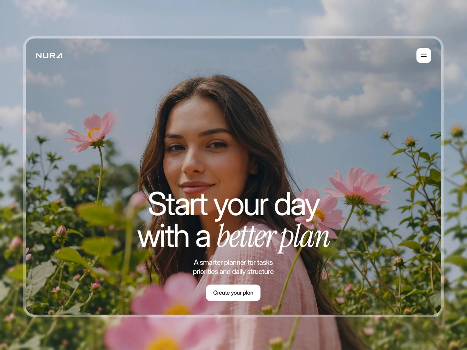 Woman smiling in a field of pink flowers under a partly cloudy sky.