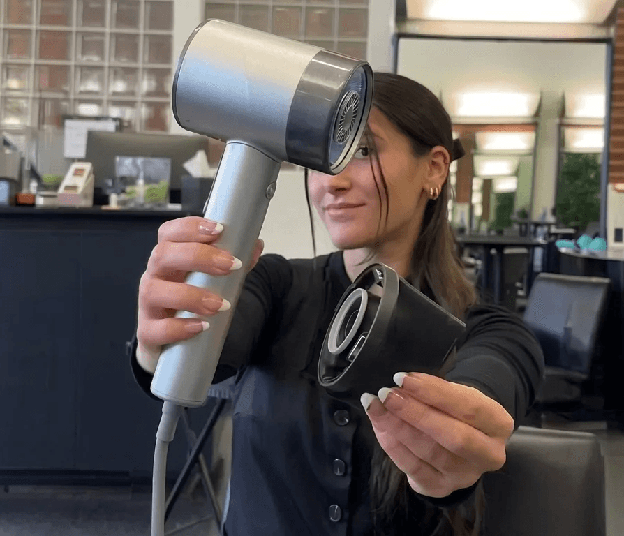 Haircare campaign showing a stylist holding a silver hair dryer