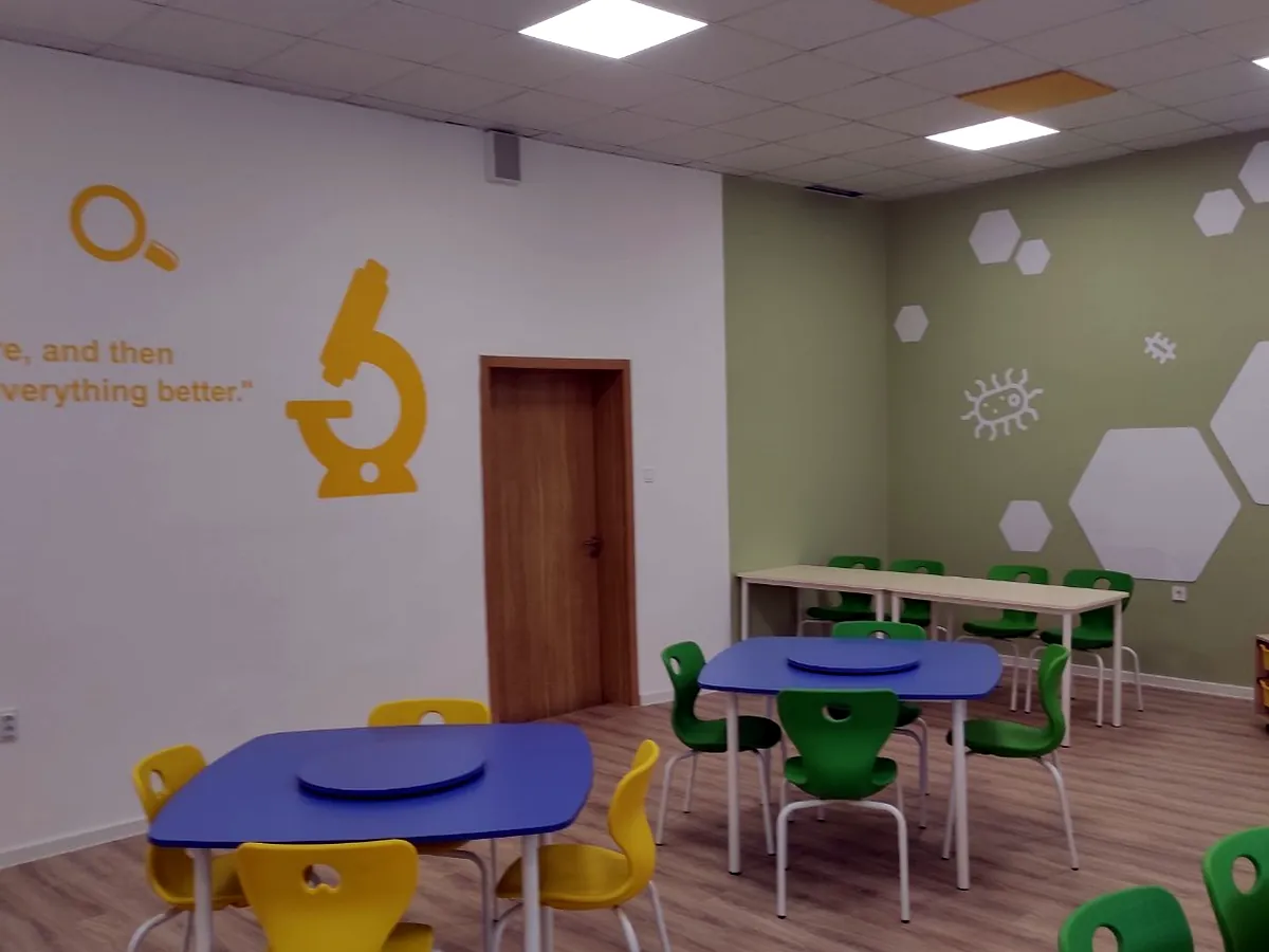 Green and blue stackable school chairs in a science learning room