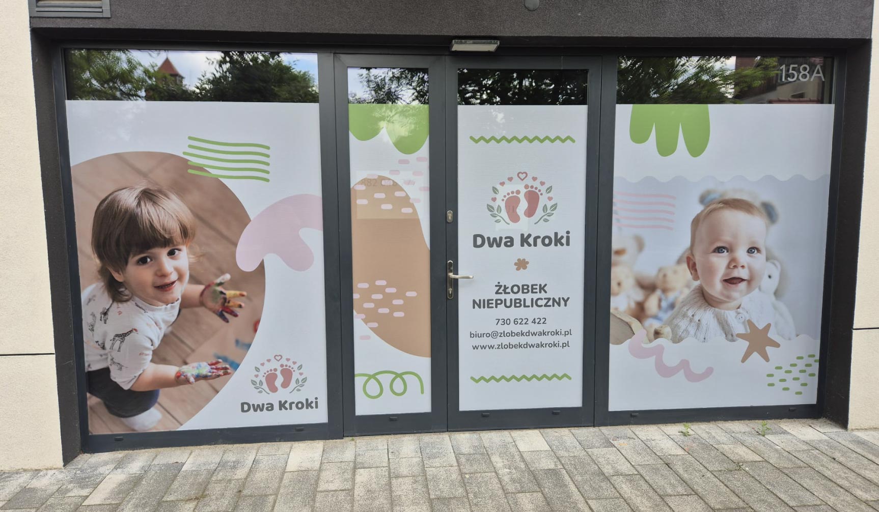 Grafiki okienne z przyjaznymi dzieciom ilustracjami dla Dwa Kroki