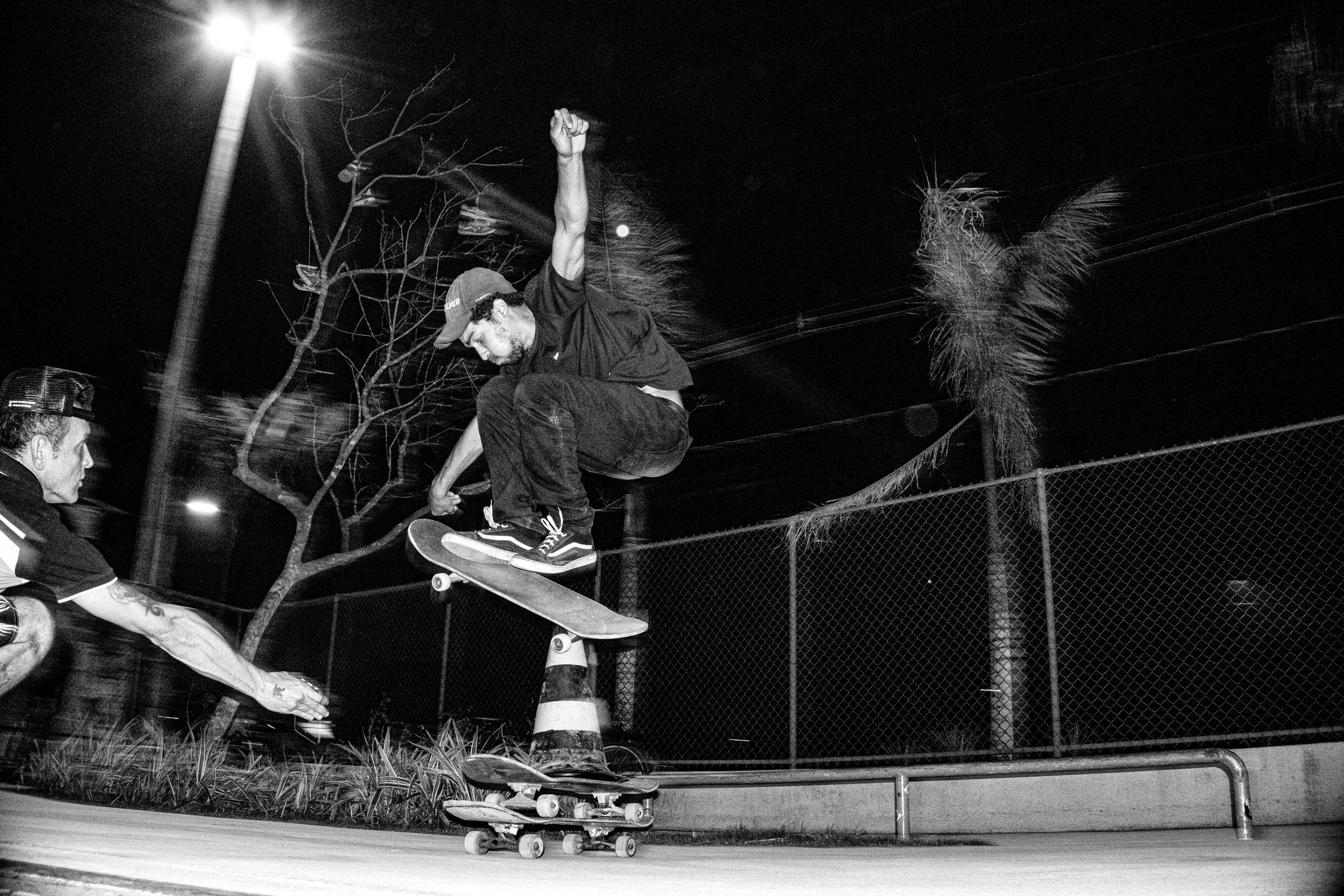 Skateboarder performs trick on traffic cone at night