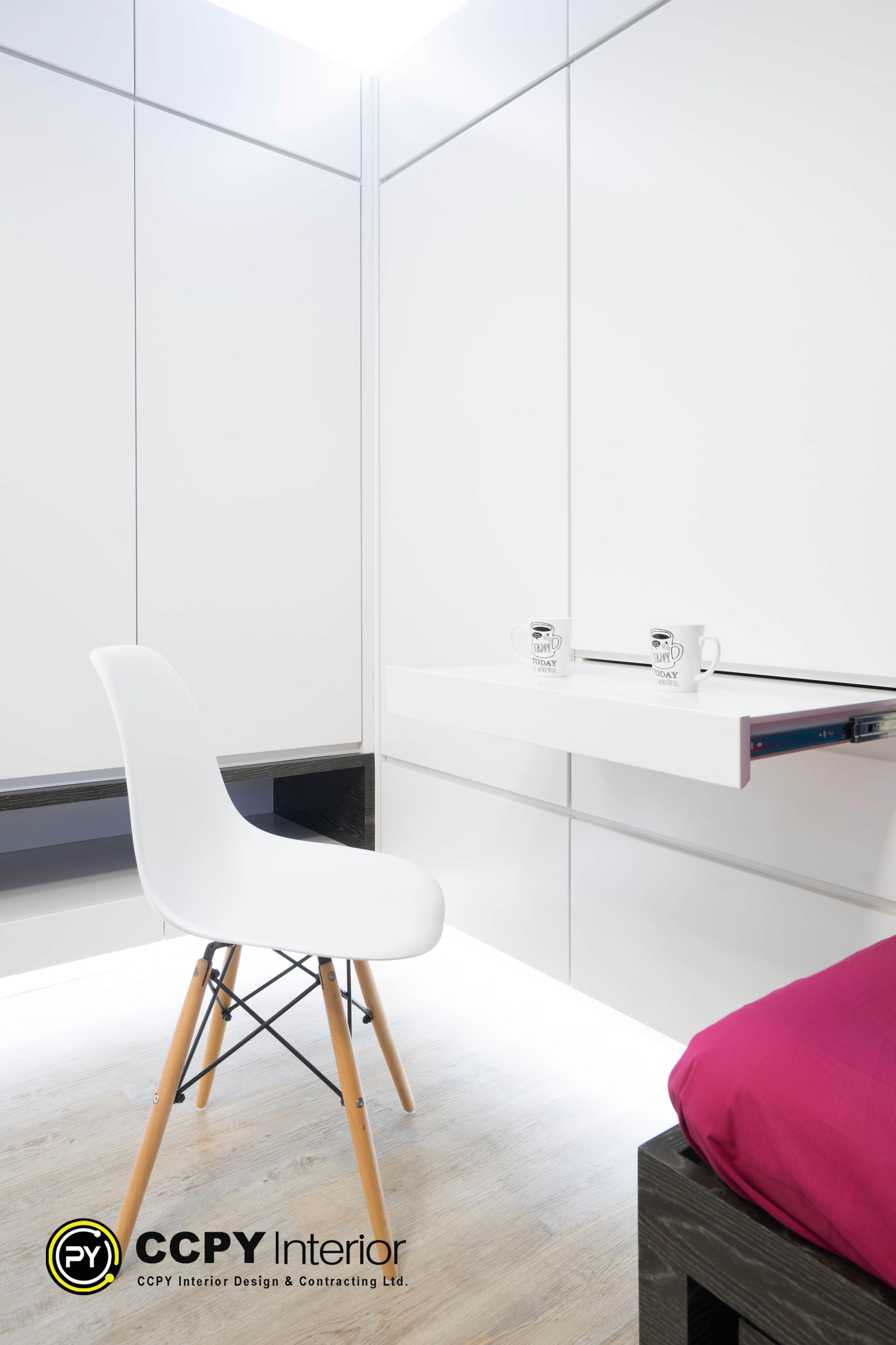 The selected region shows a minimalist, white space-saving furniture solution featuring a pull-out desk integrated into custom wall cabinetry.Space-Saving FeaturesRetractable Desk: The main work surface slides smoothly out of the wall unit using heavy-duty side runners, allowing it to be tucked away completely when not in use.Integrated Cabinetry: The desk seamlessly blends into the flat-panel, handleless white wardrobe or storage system, maintaining a clean visual line.Hidden Storage: A recessed dark niche is visible underneath the cabinetry, providing a functional footrest or a spot to slide a chair out of the main walkway.
