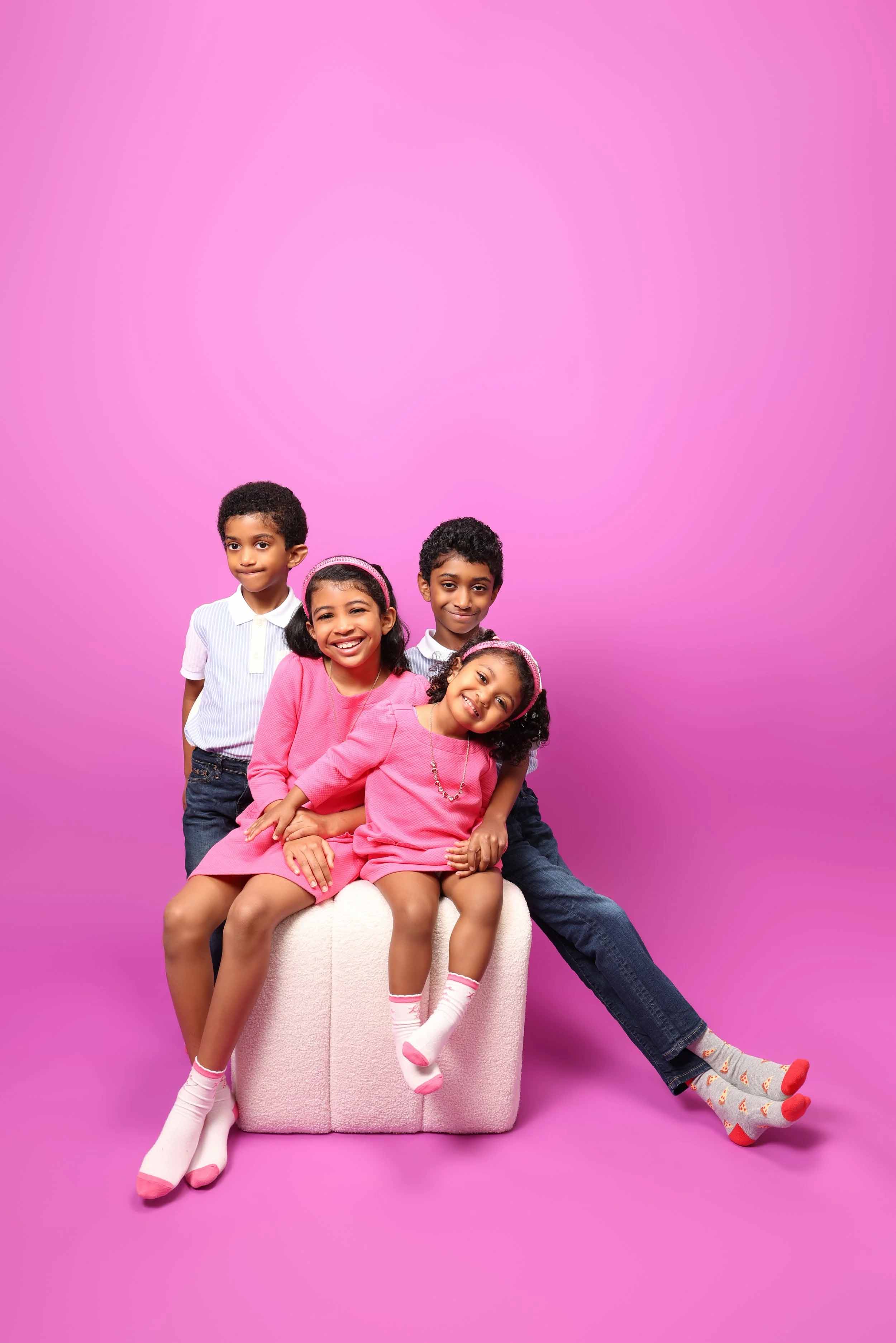 Family portrait on a bright pink backdrop