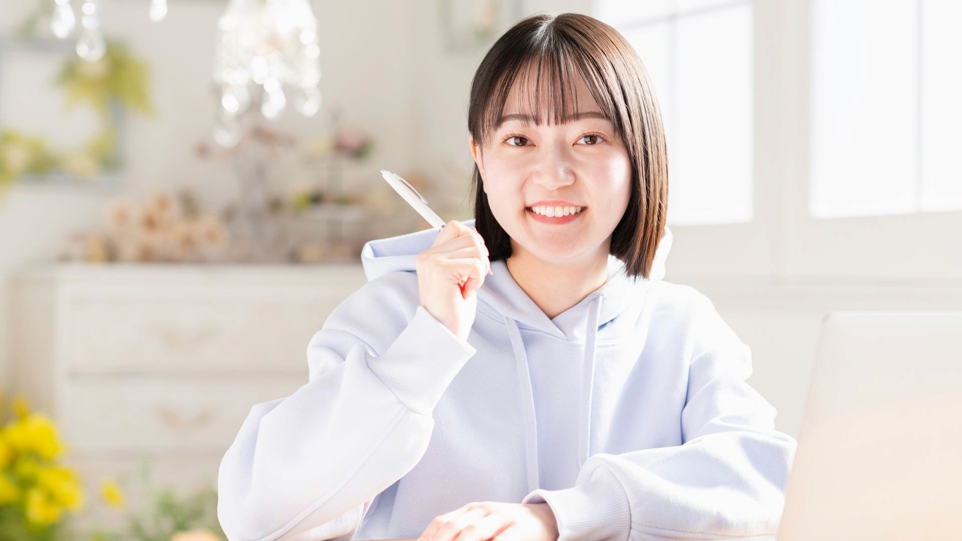 リビングでノートパソコンを使う若い女性