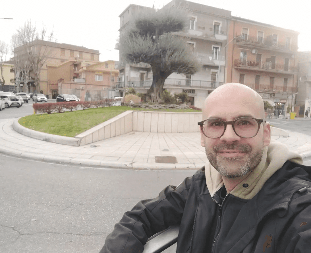 zona centrale di guidonia davanti stazione ferroviaria con carlo e sfondo di olivo al centro della rotonda