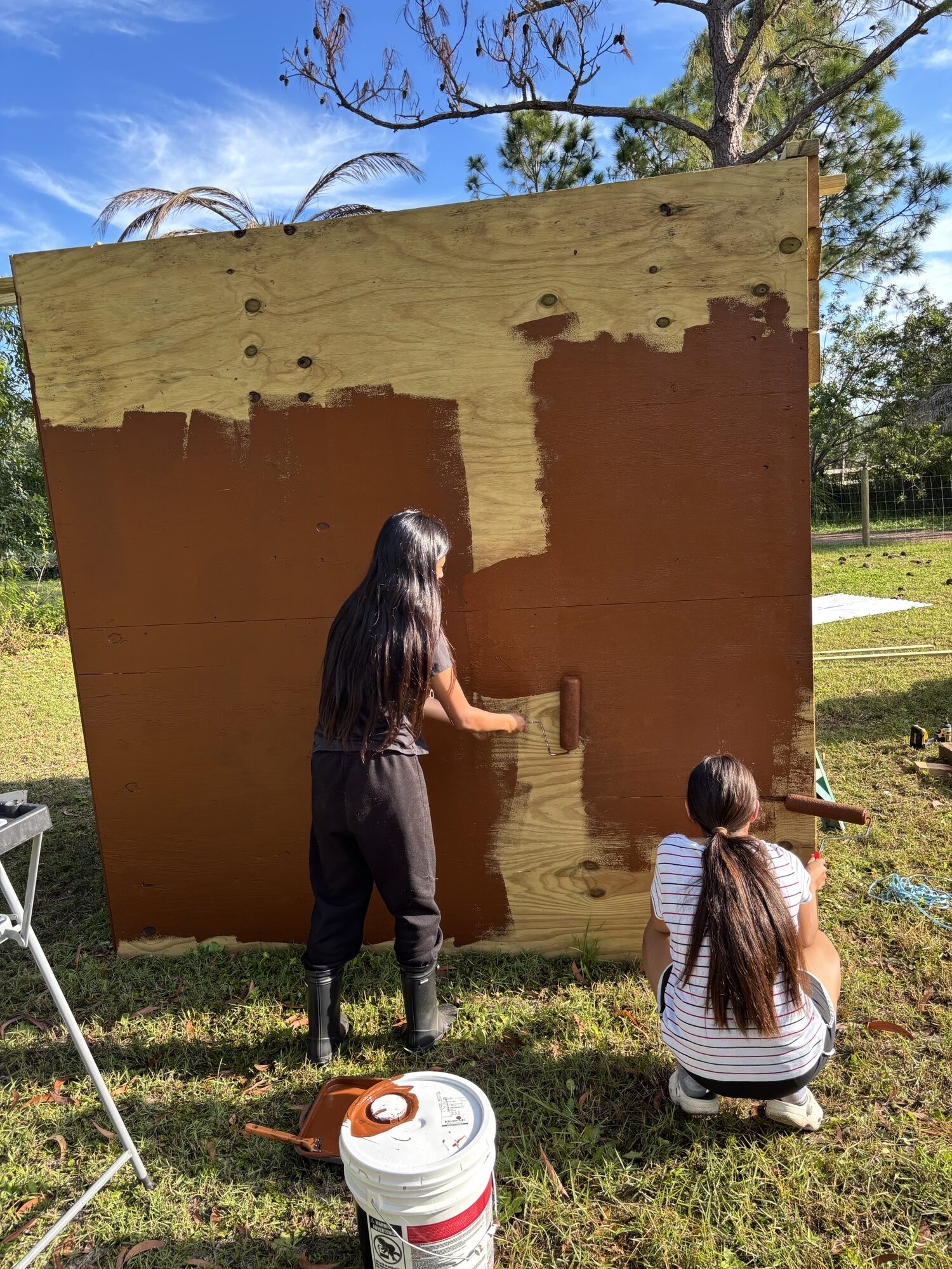 Young people painting an outdoor structure together at the Fellsmere learning site