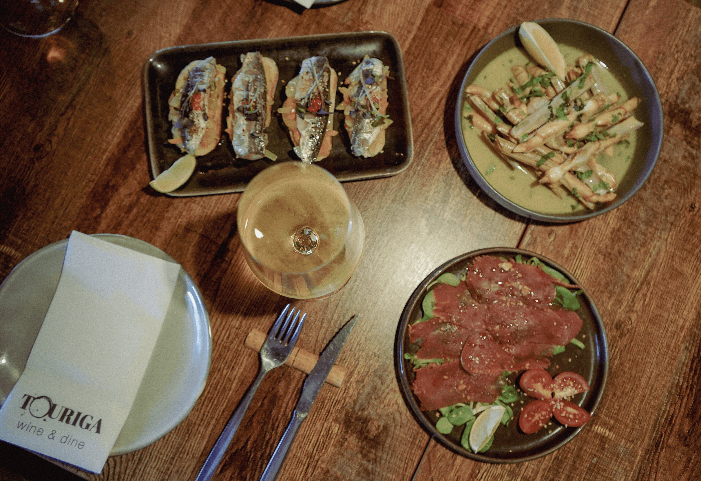 A close-up of a hand wearing multiple decorative rings against a blue background.
