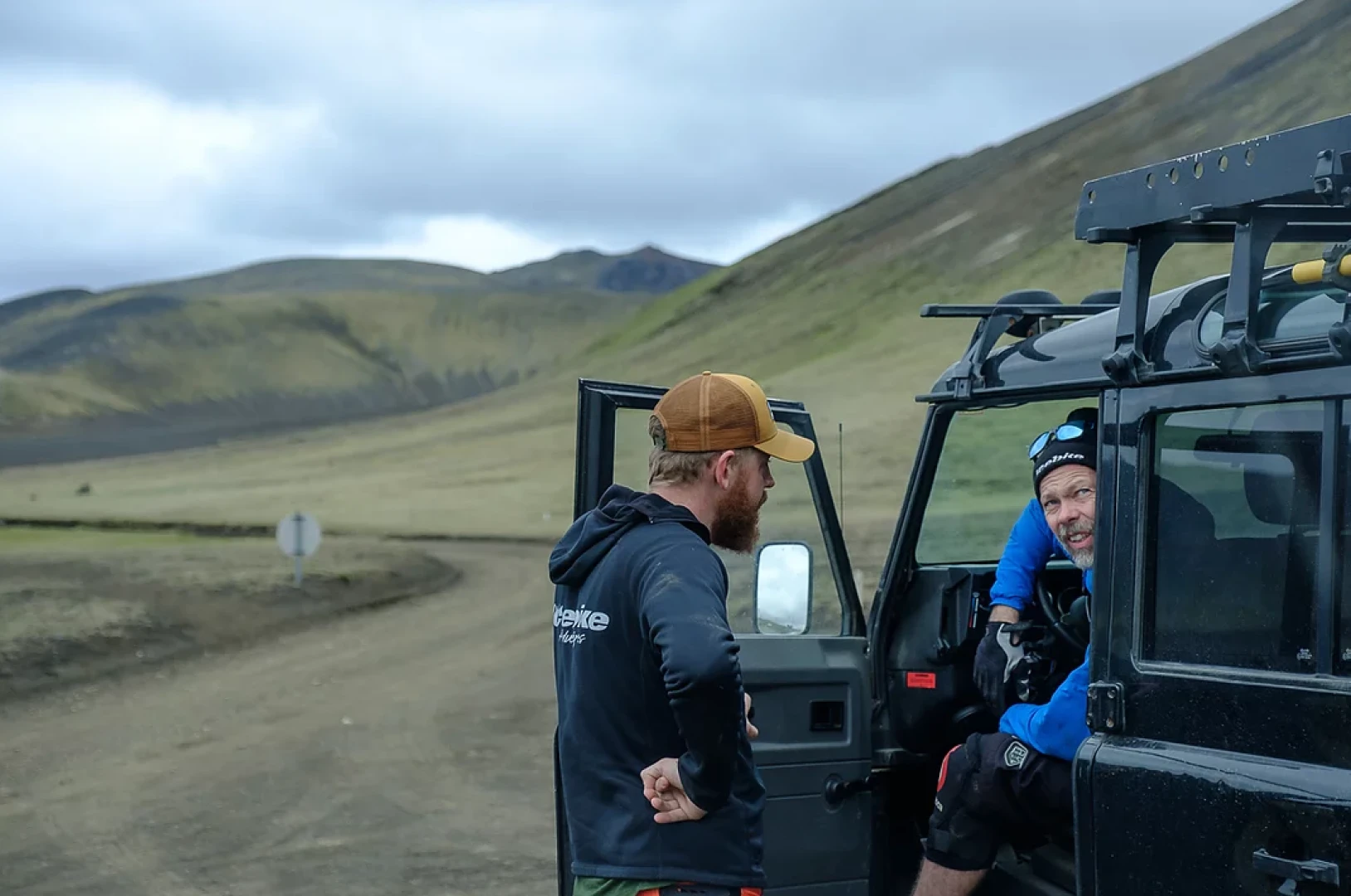 Magne sits in landrover and talks to a guide on a mountainbike trip in Iceland