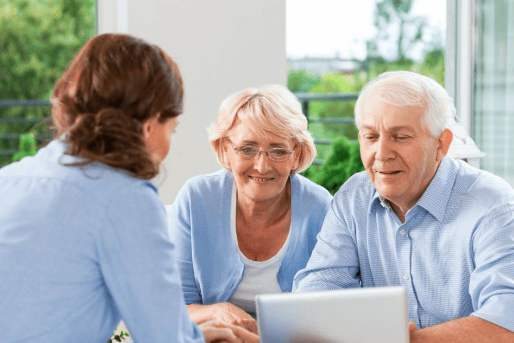 An older couple looking at a laptop with younger woman