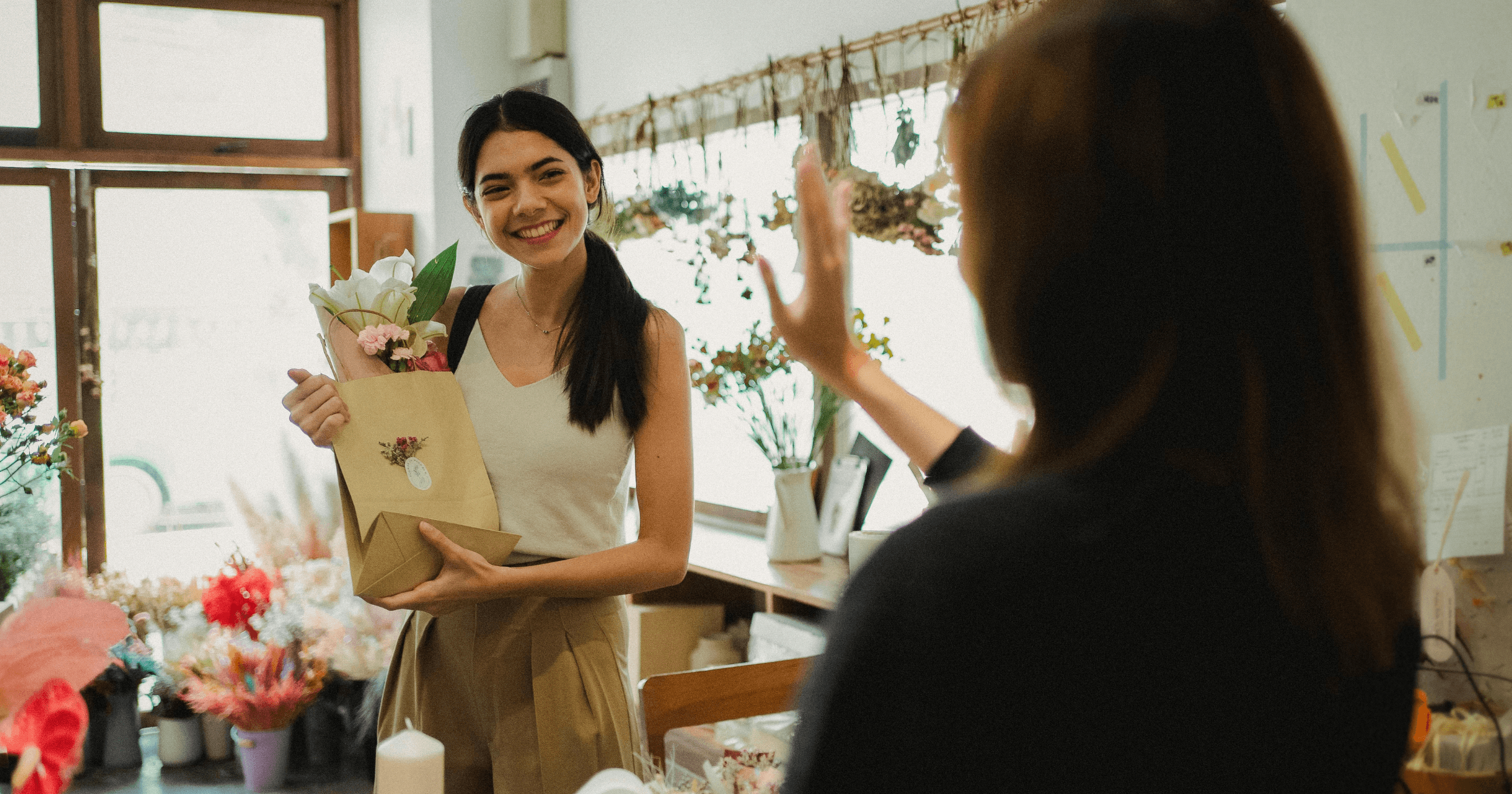 A Filipino retail owner waving goodbye to a customer
