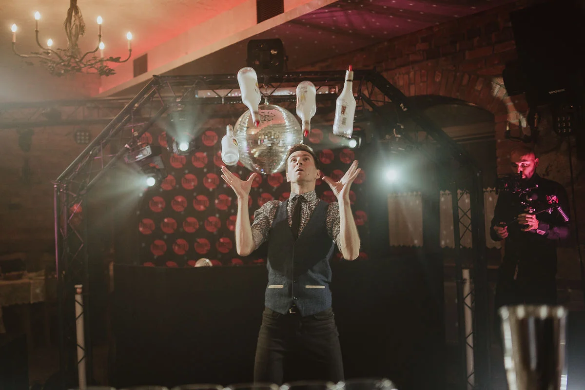 Drink bar na weselu z barmanem zachwycającym gości podczas pokazu.