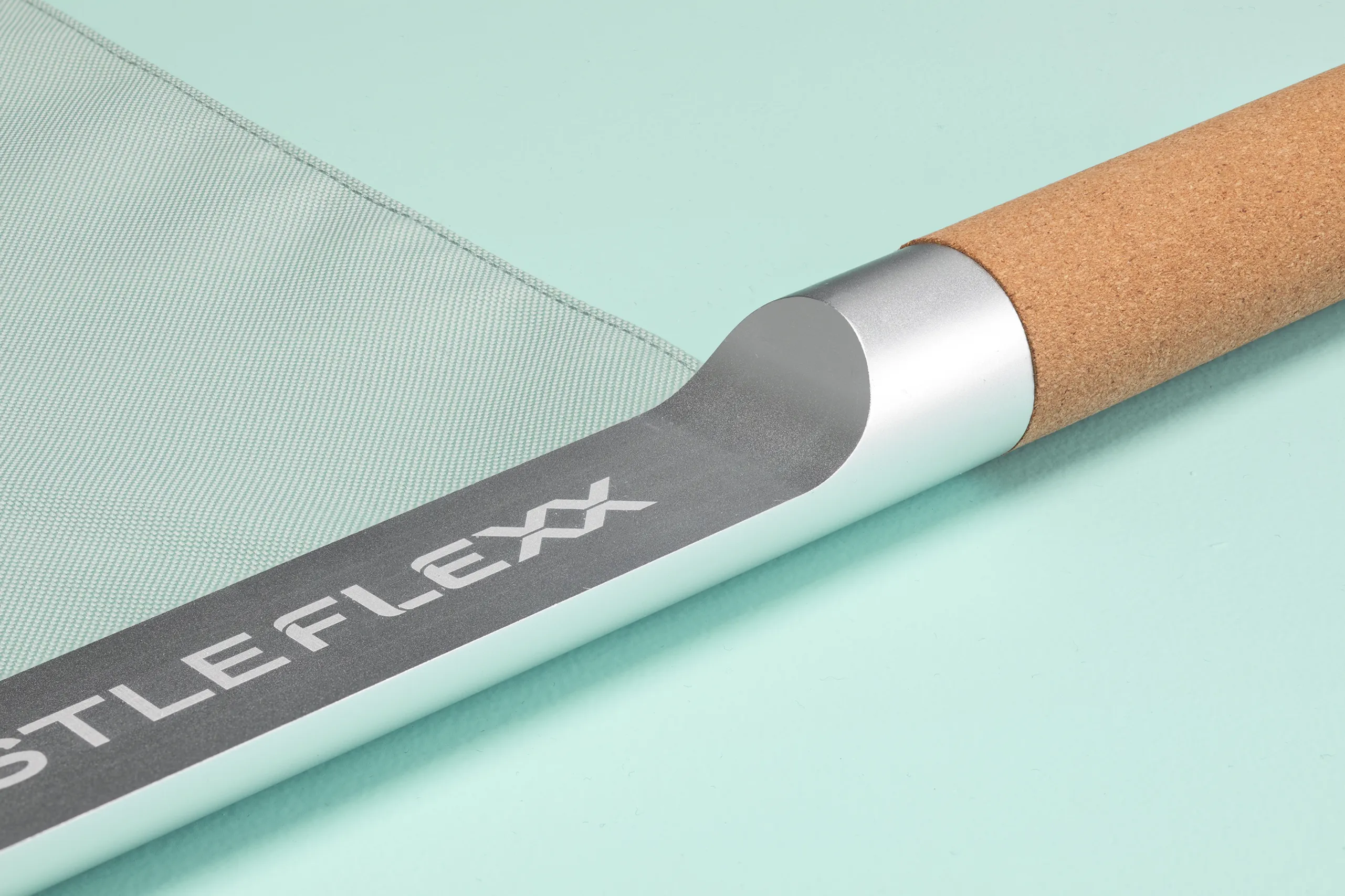 Close-up of the CastleFlexx cork handle, metal connection, and branded fabric strap