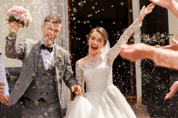 Smiling bride and groom leaving their wedding ceremoy.