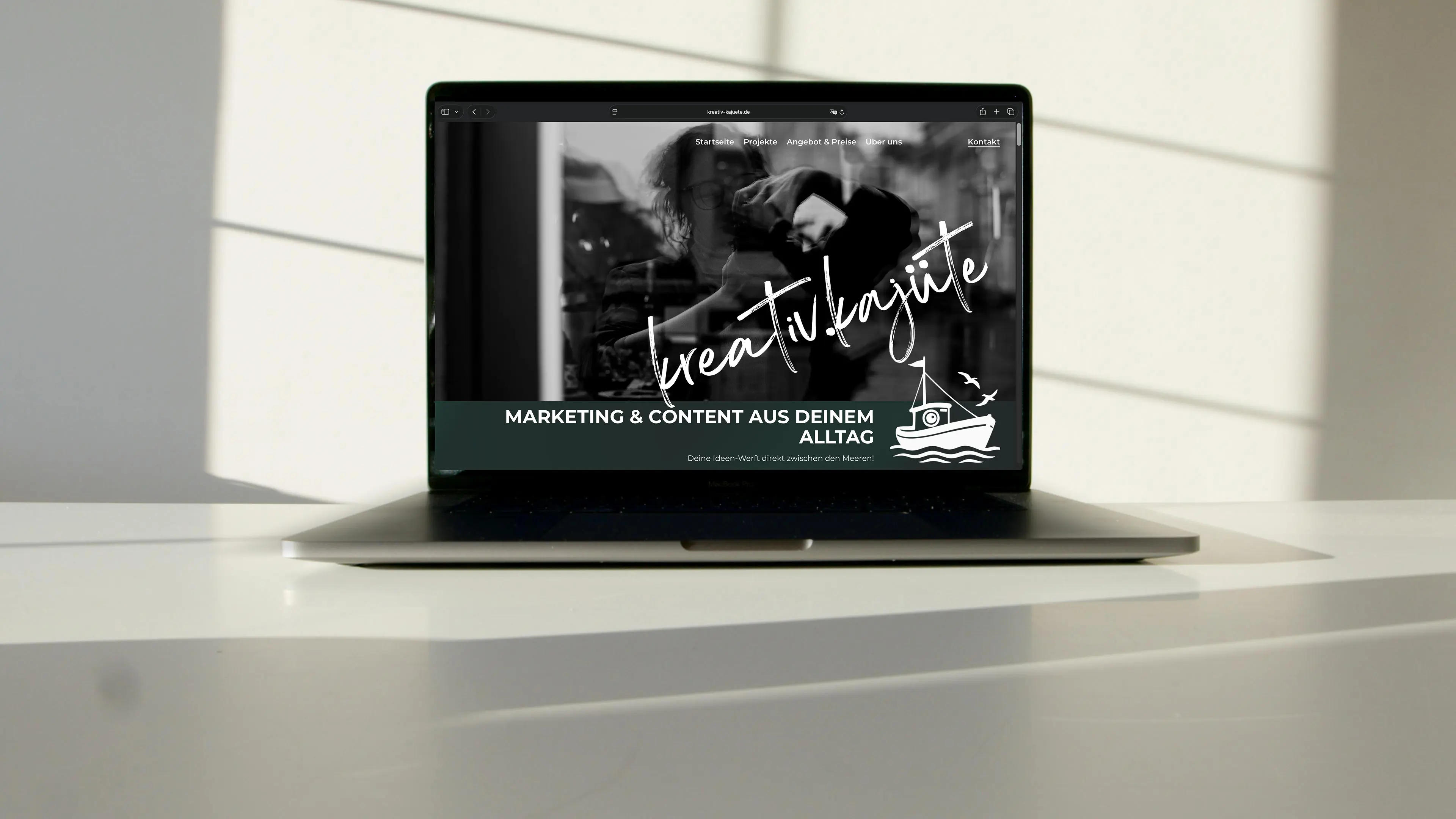 Ein Laptop steht auf einem Tisch der ein Wireframe für eine Website