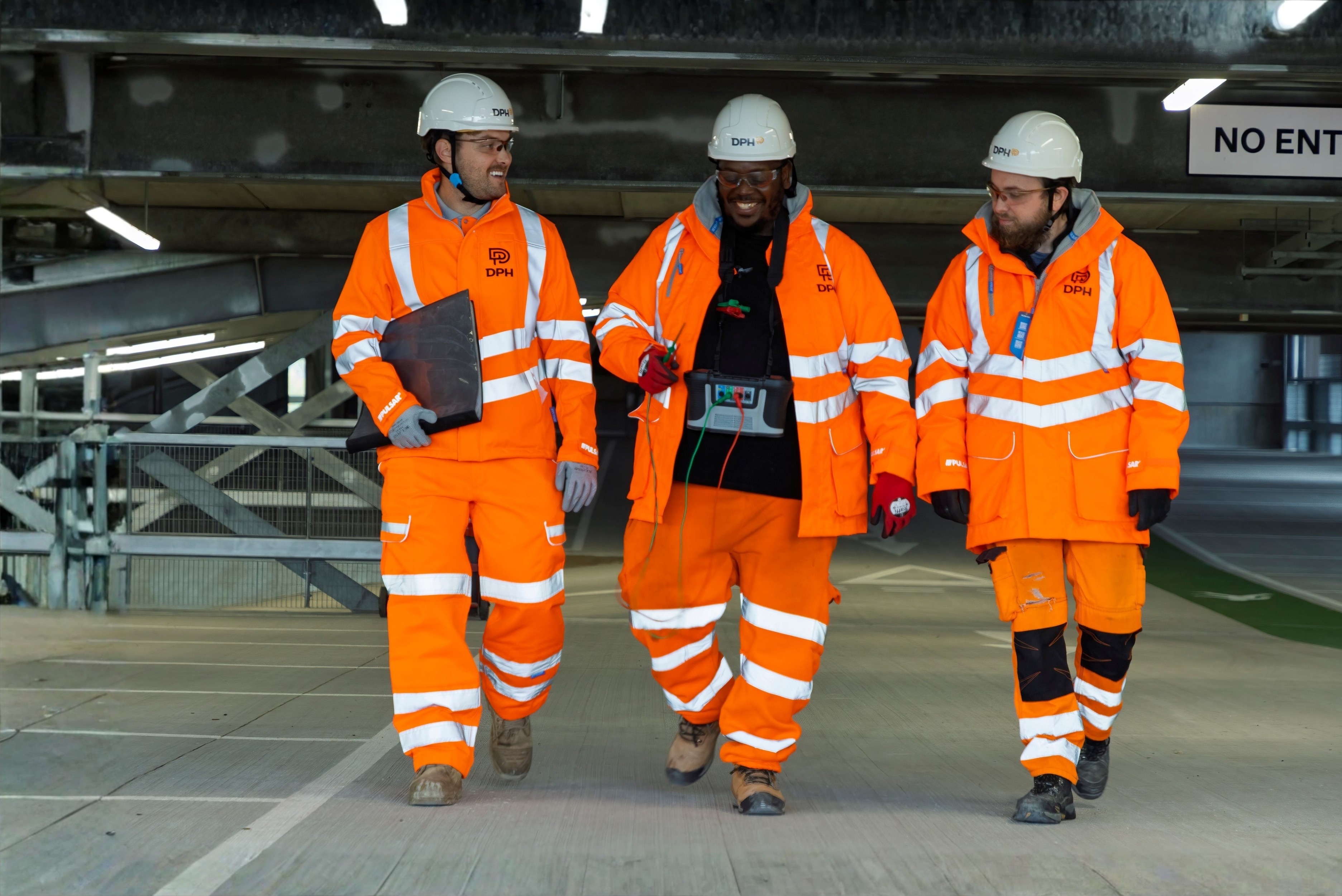 Modern glass buildings with illuminated facades and trees on a rainy day