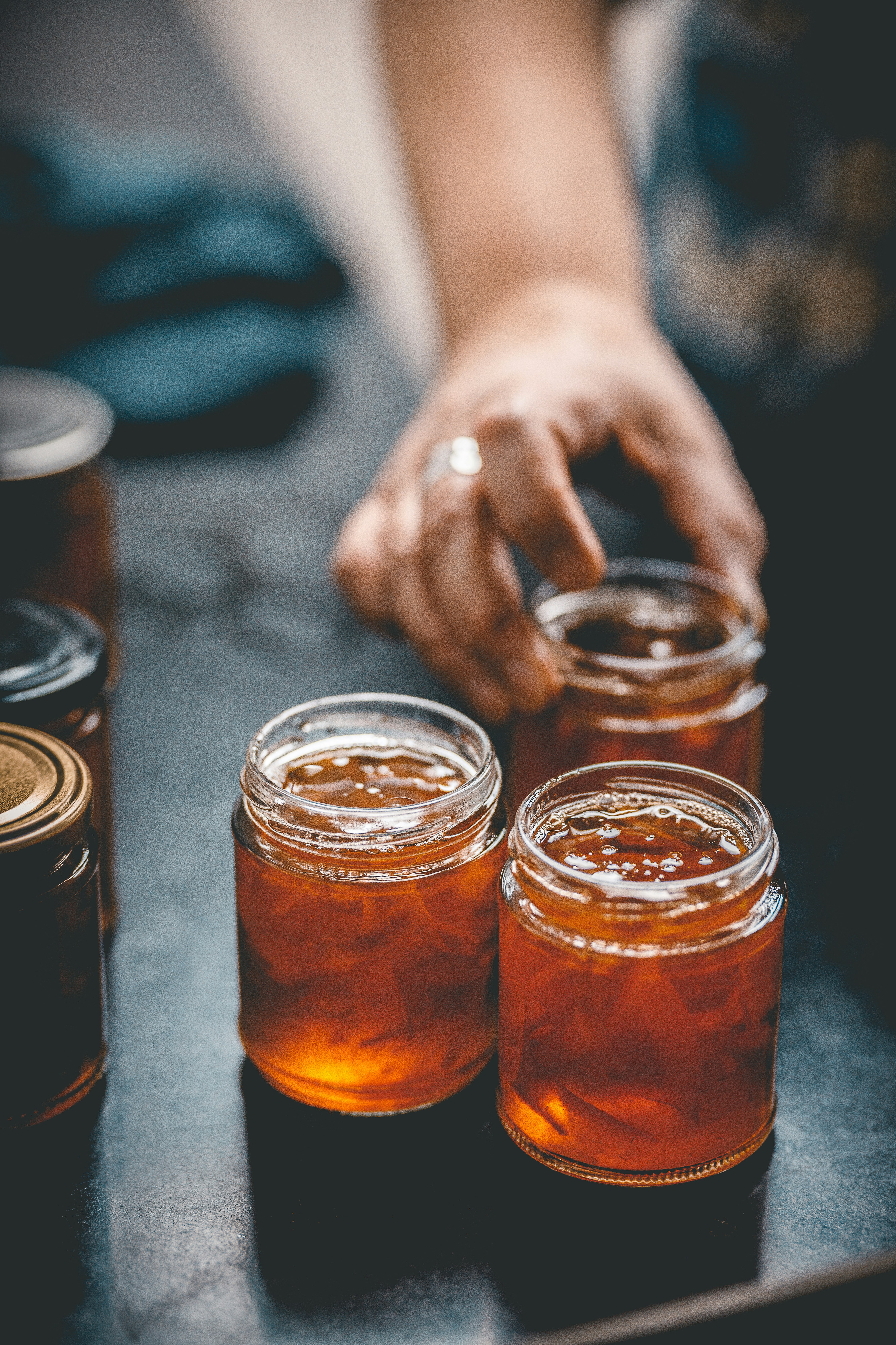 close-up of a hand near honey jars