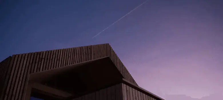 Oberkante der Lattenfassade vor dunkelblauem Himmel nach Sonnenuntergang