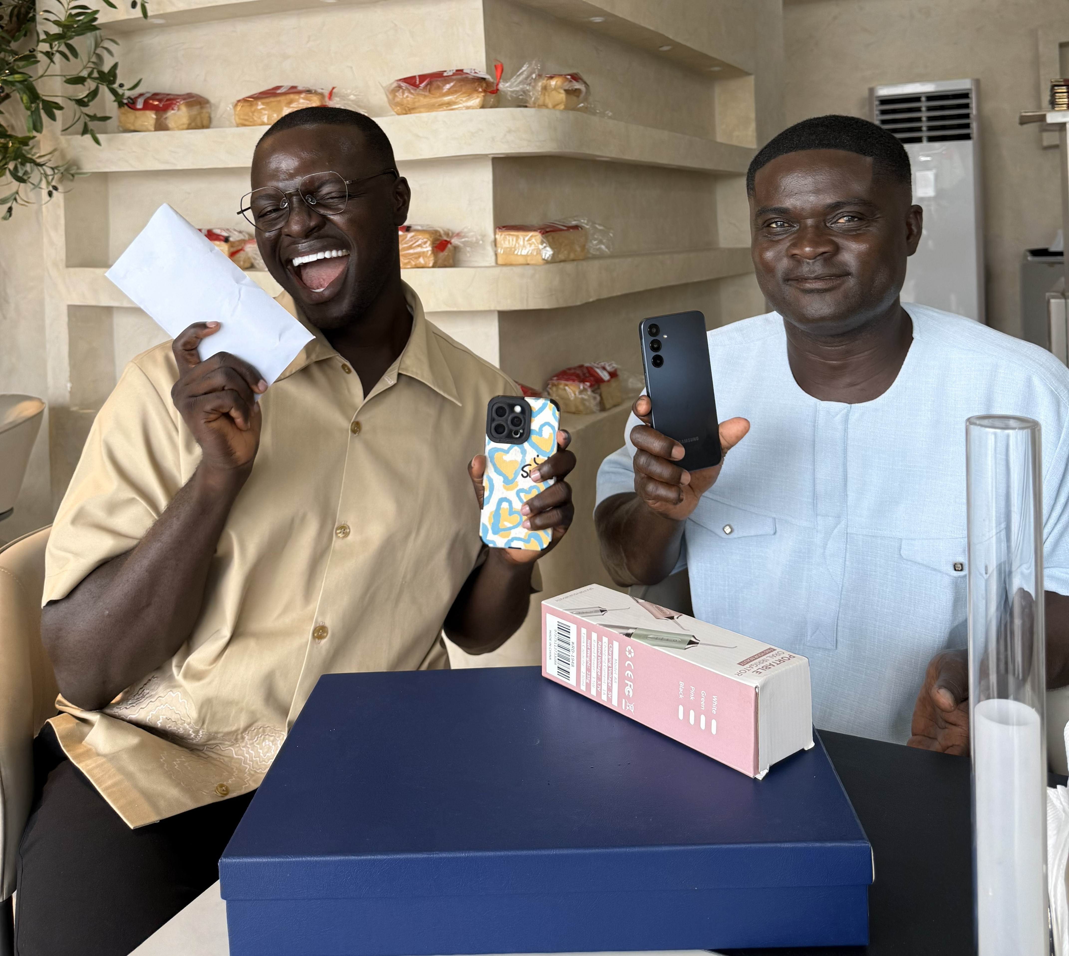 person in gray hoodie holding red and white box