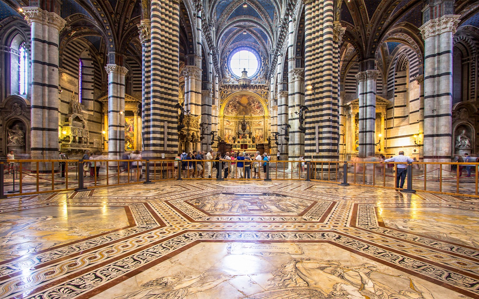 Siena Cathedral interior with striped columns and ornate marble floor, Italy.