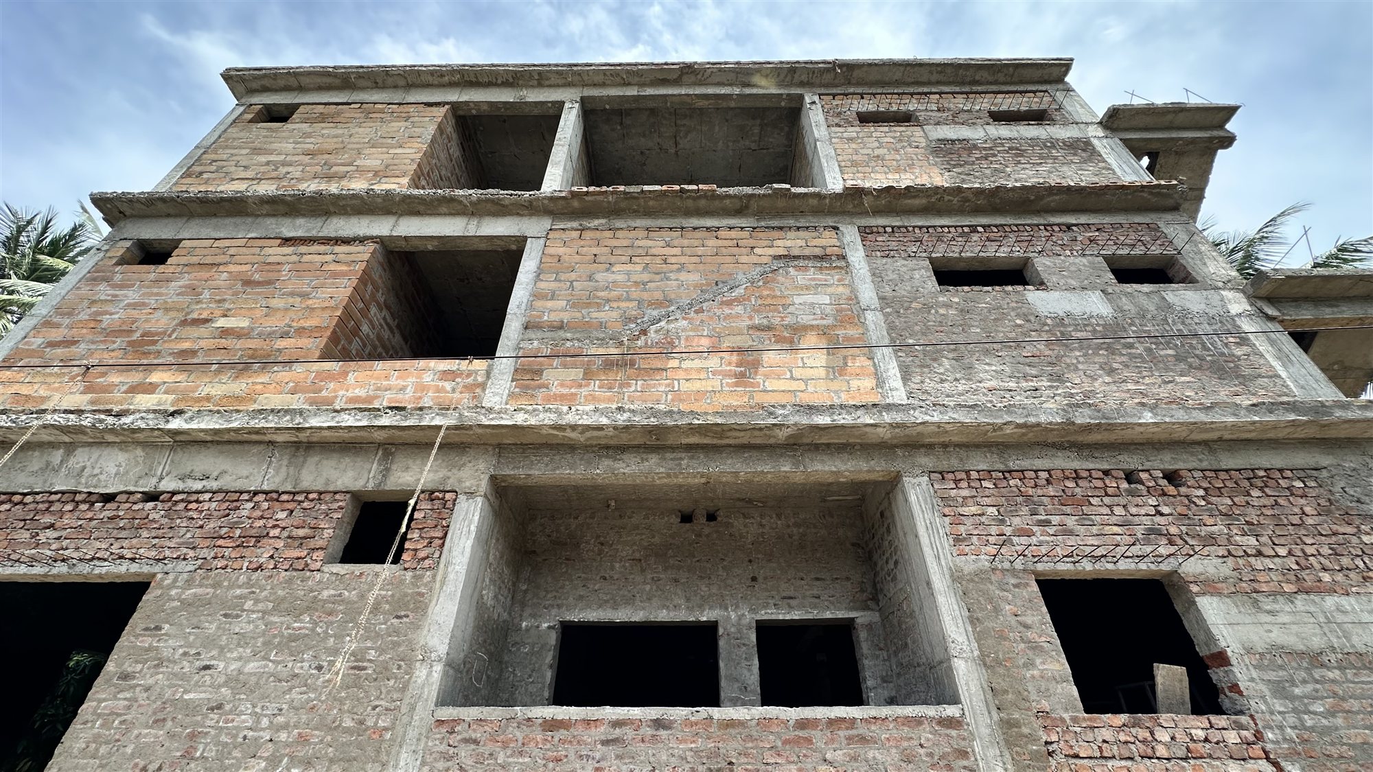 Three-storey family home in Rajahmundry with warm-toned Agrocrete® walls on the upper floors
