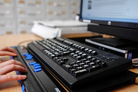 A visually impaired person using a braille keyboard to take a 508 compliant elearning course