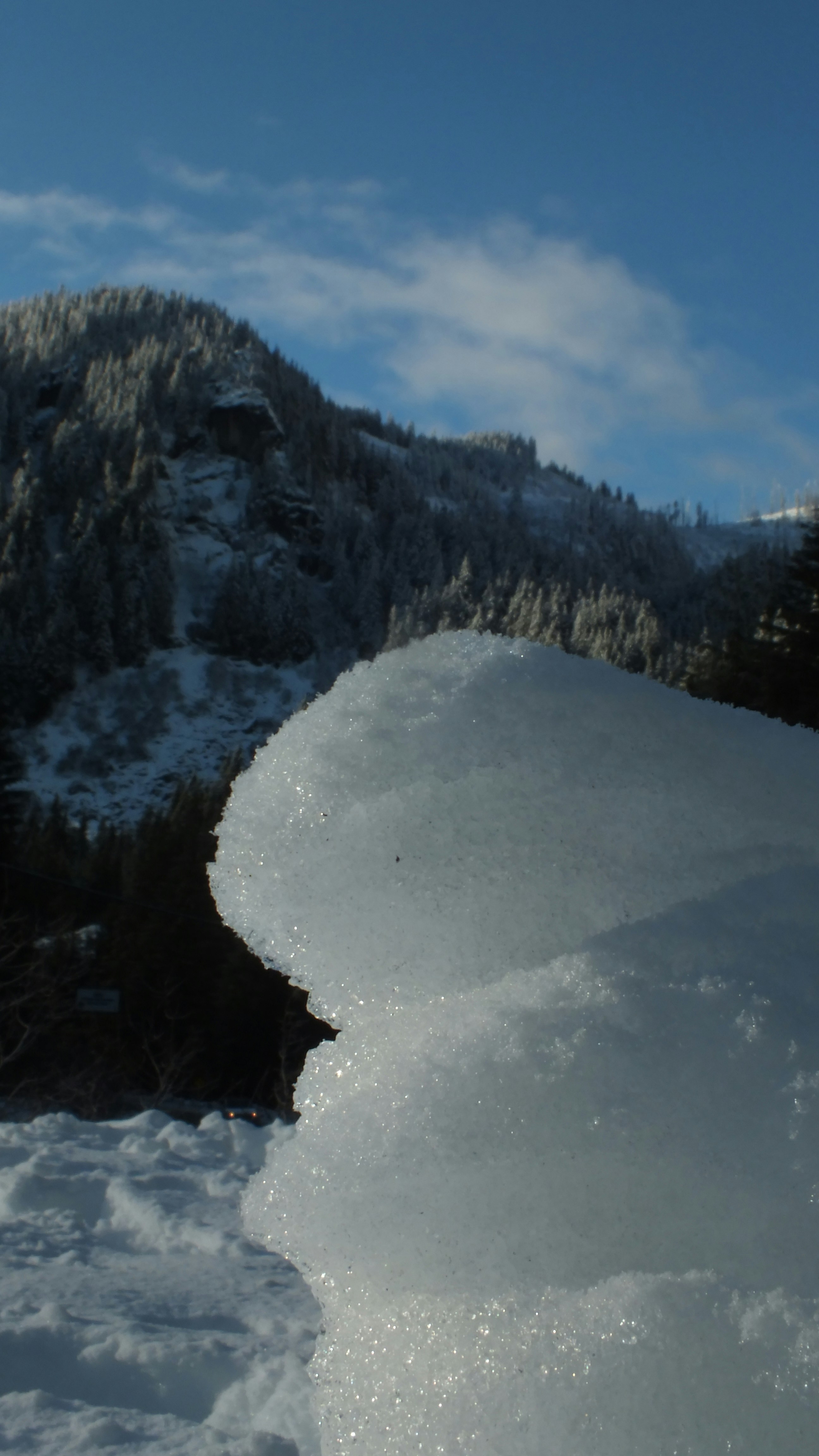 A person riding a snowboard down a snow covered slope