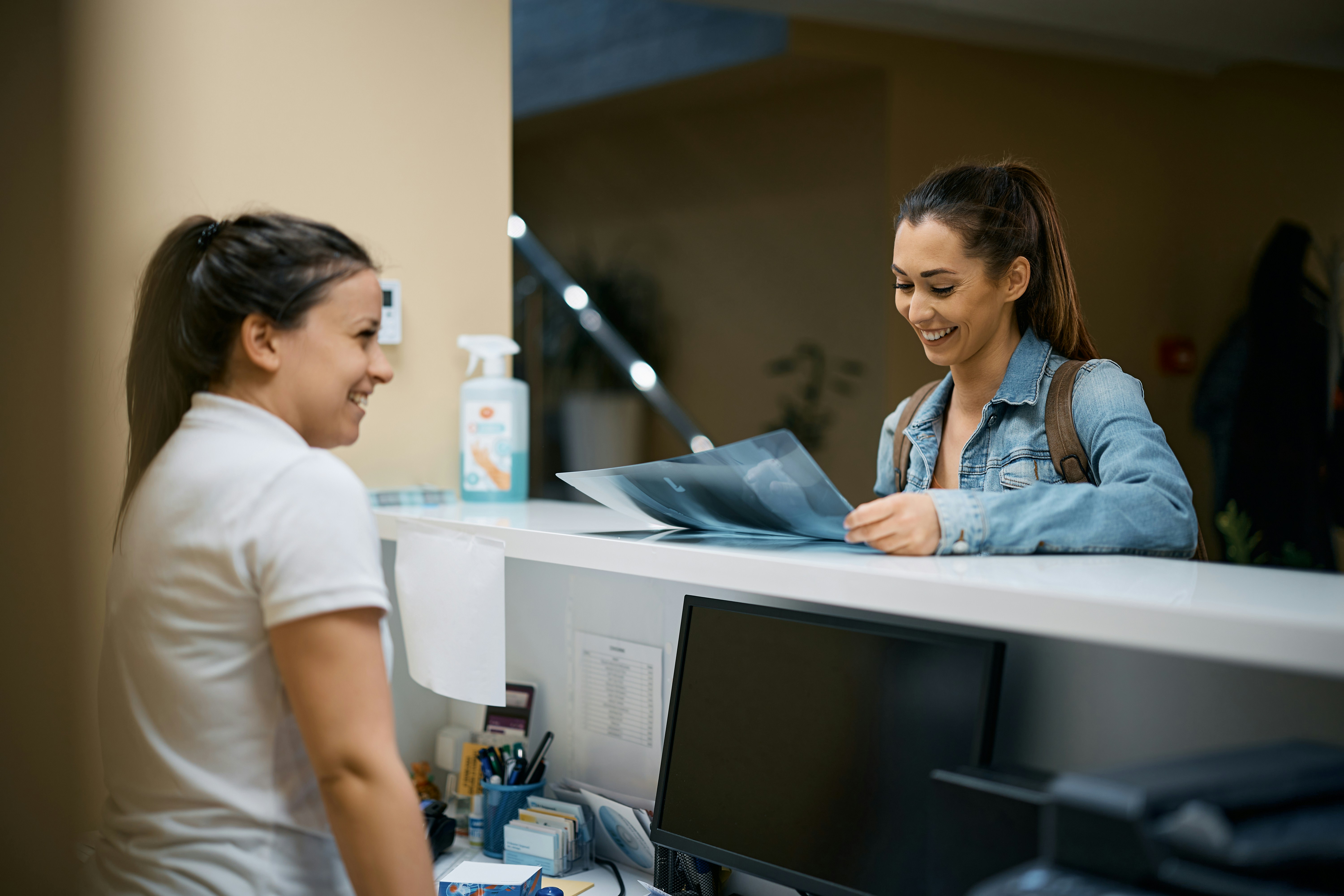 Medical practice patient check-in experience showing positive patient and staff interaction at a modern medical office