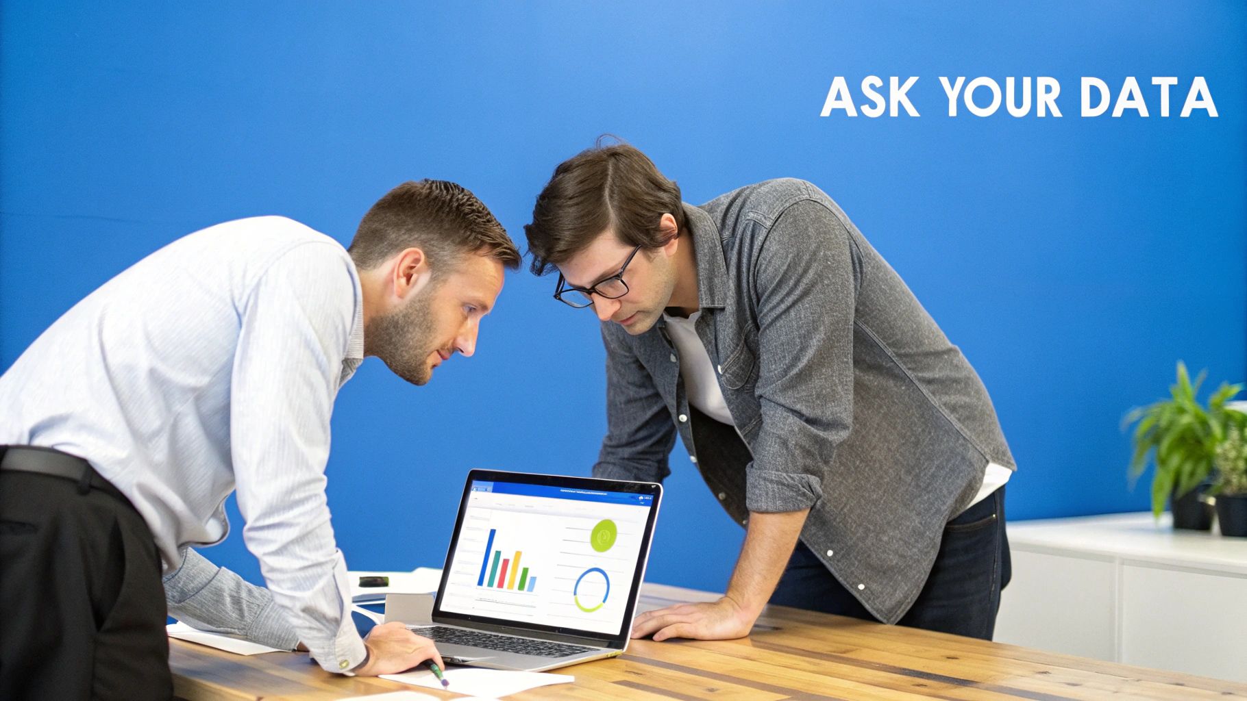 Two business professionals analyzing colorful data visualizations and charts on laptop computer screen
