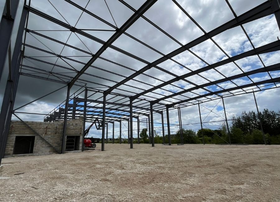 Vue intérieure d’une charpente métallique en cours d’assemblage sur un chantier industriel.