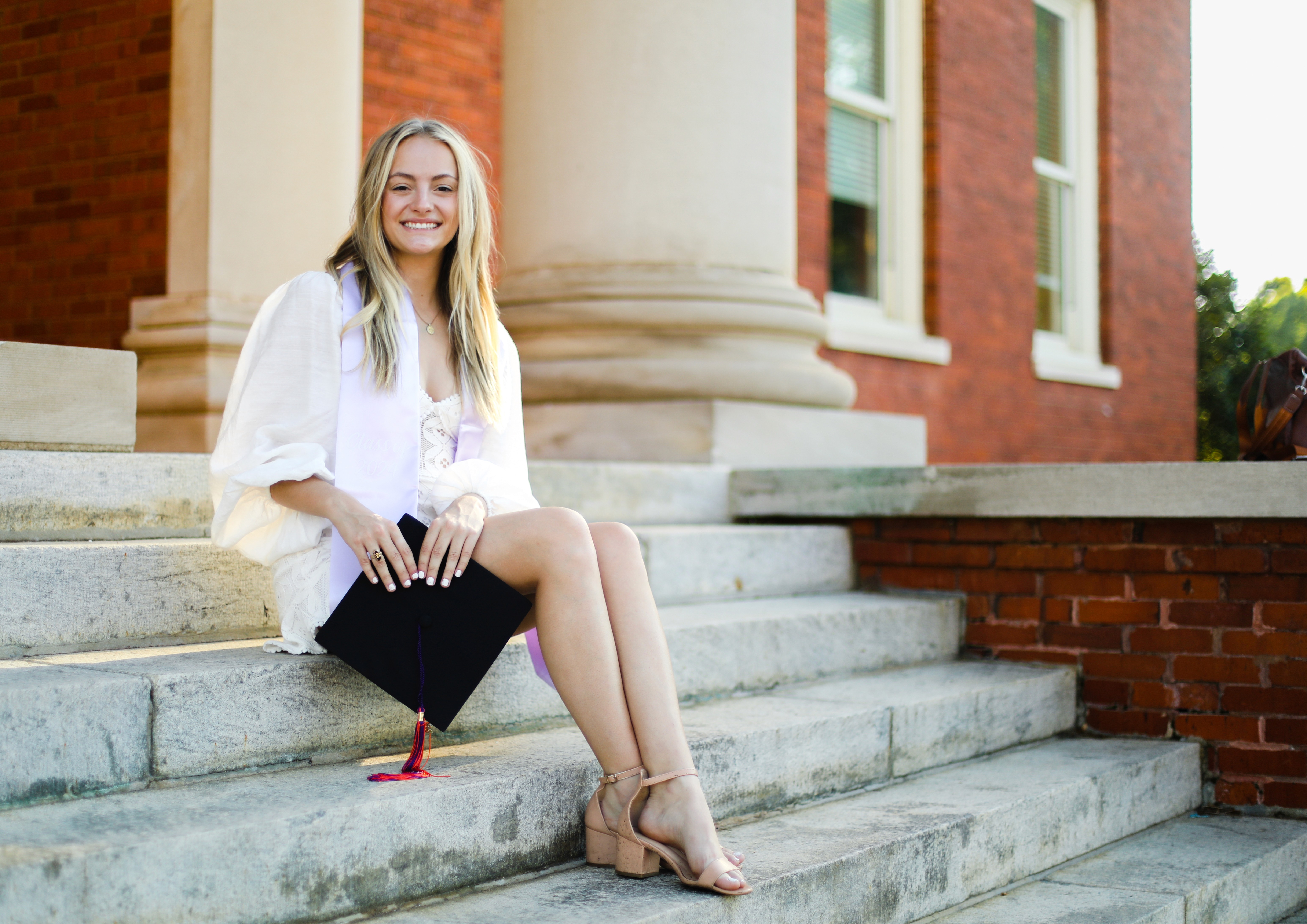 South Carolina 529 Plan college graduate holding her cap outdoors on graduation day.