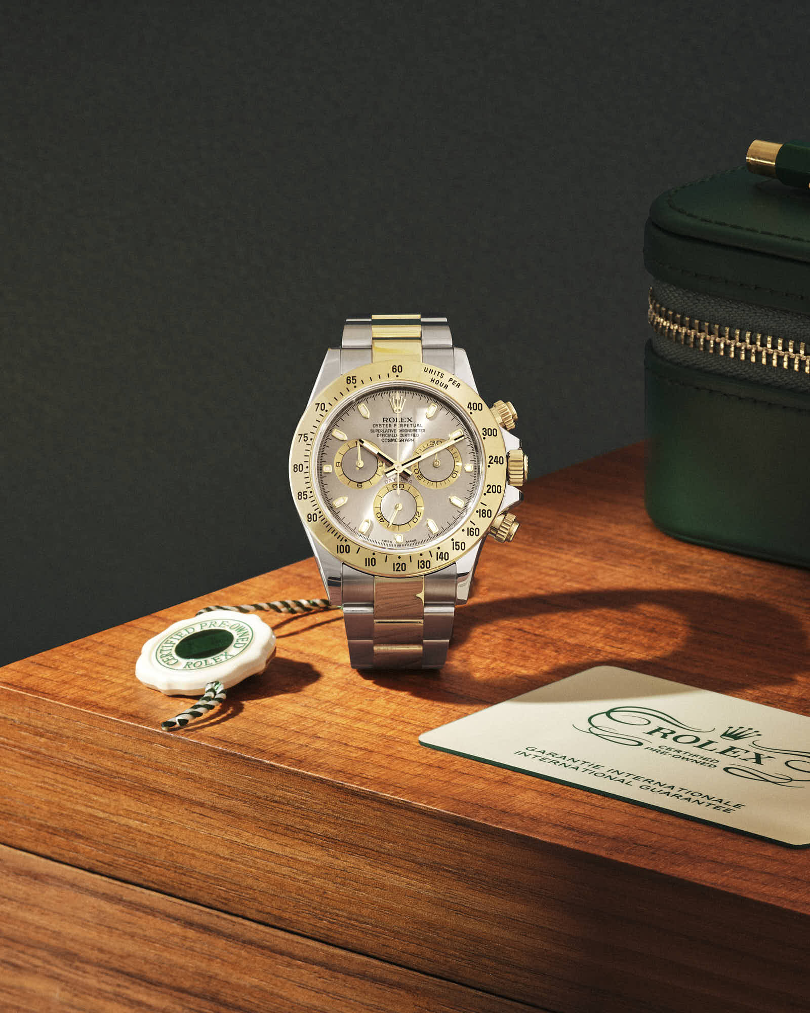 Luxury Rolex Daytona watch on display with certification tag and green case.