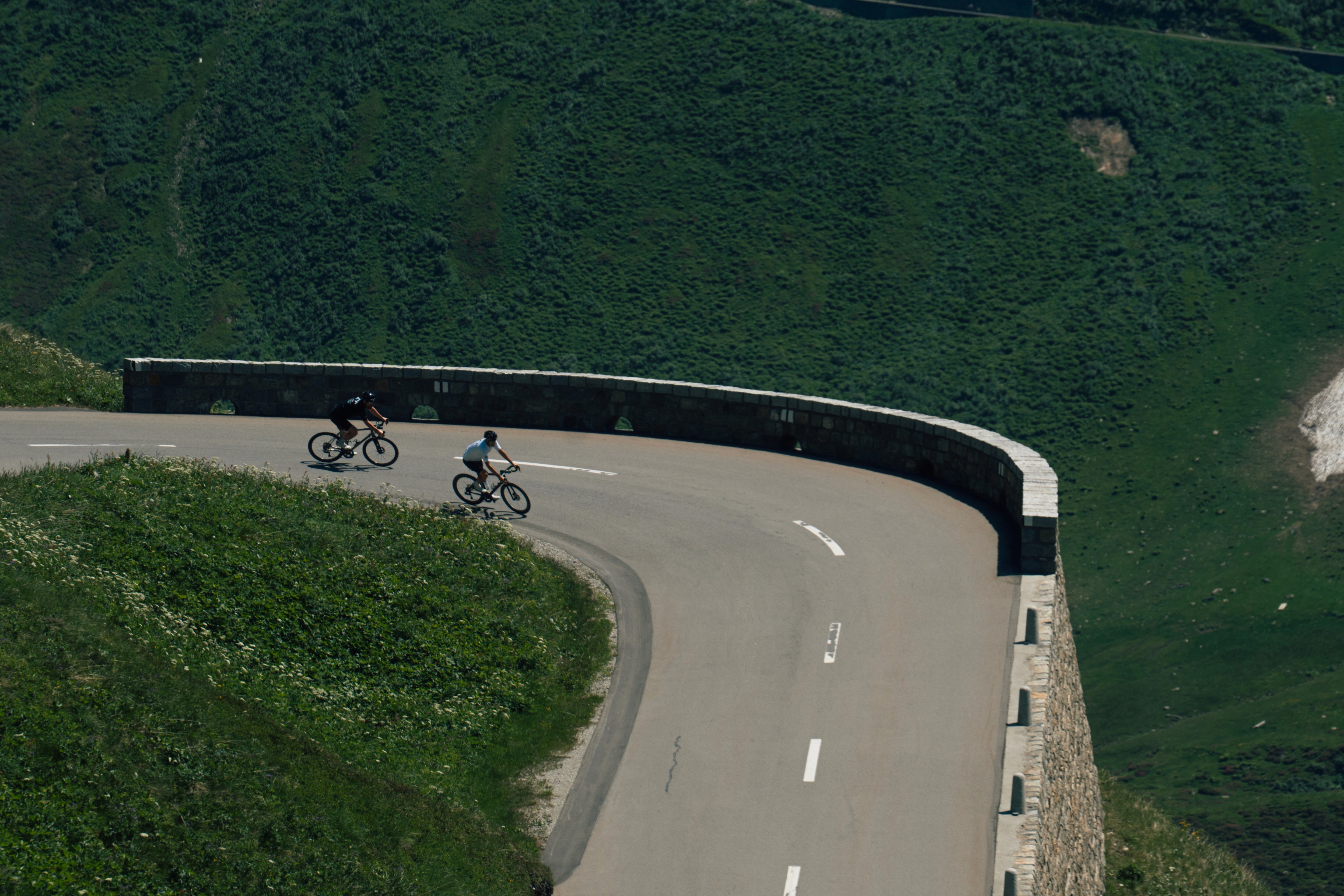 Cyclists descending a mountain as part of the Alpenbrevet 2025