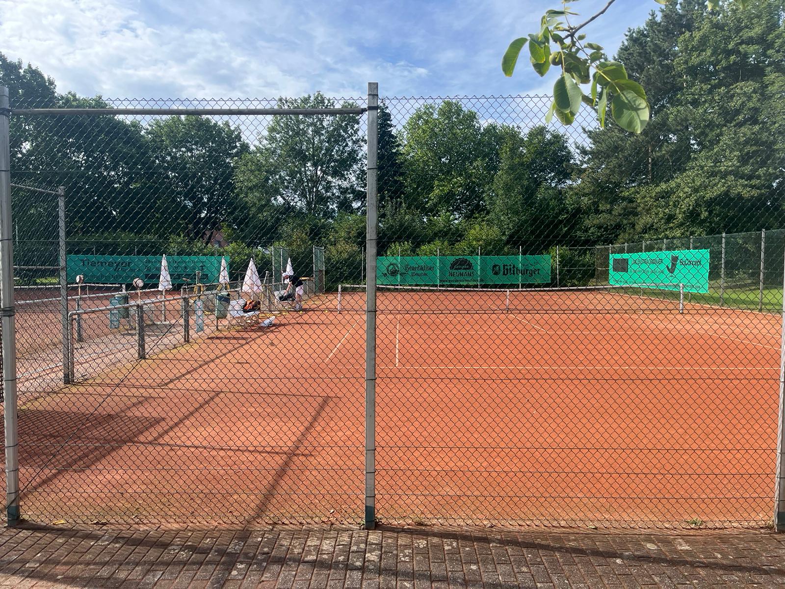 person in black shorts holding green tennis racket