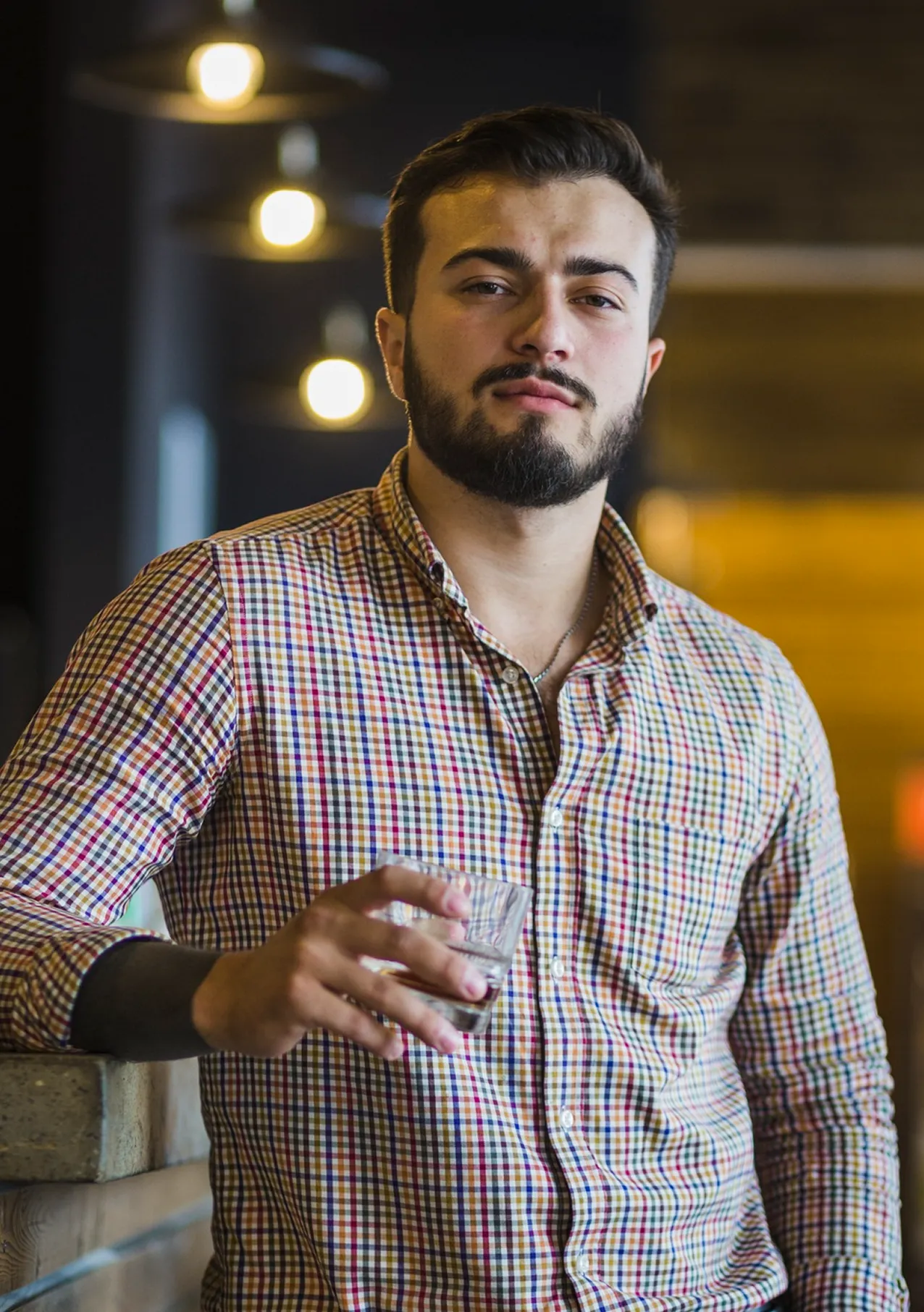Arjun Patel, Lead Site Supervisor, posing in a patterned shirt within a contemporary industrial setting.