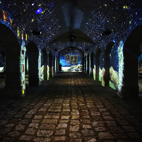 黑暗的石廊,拱形柱子上投射出星空和风景的光影,墙壁和天花板上也有类似的投影。