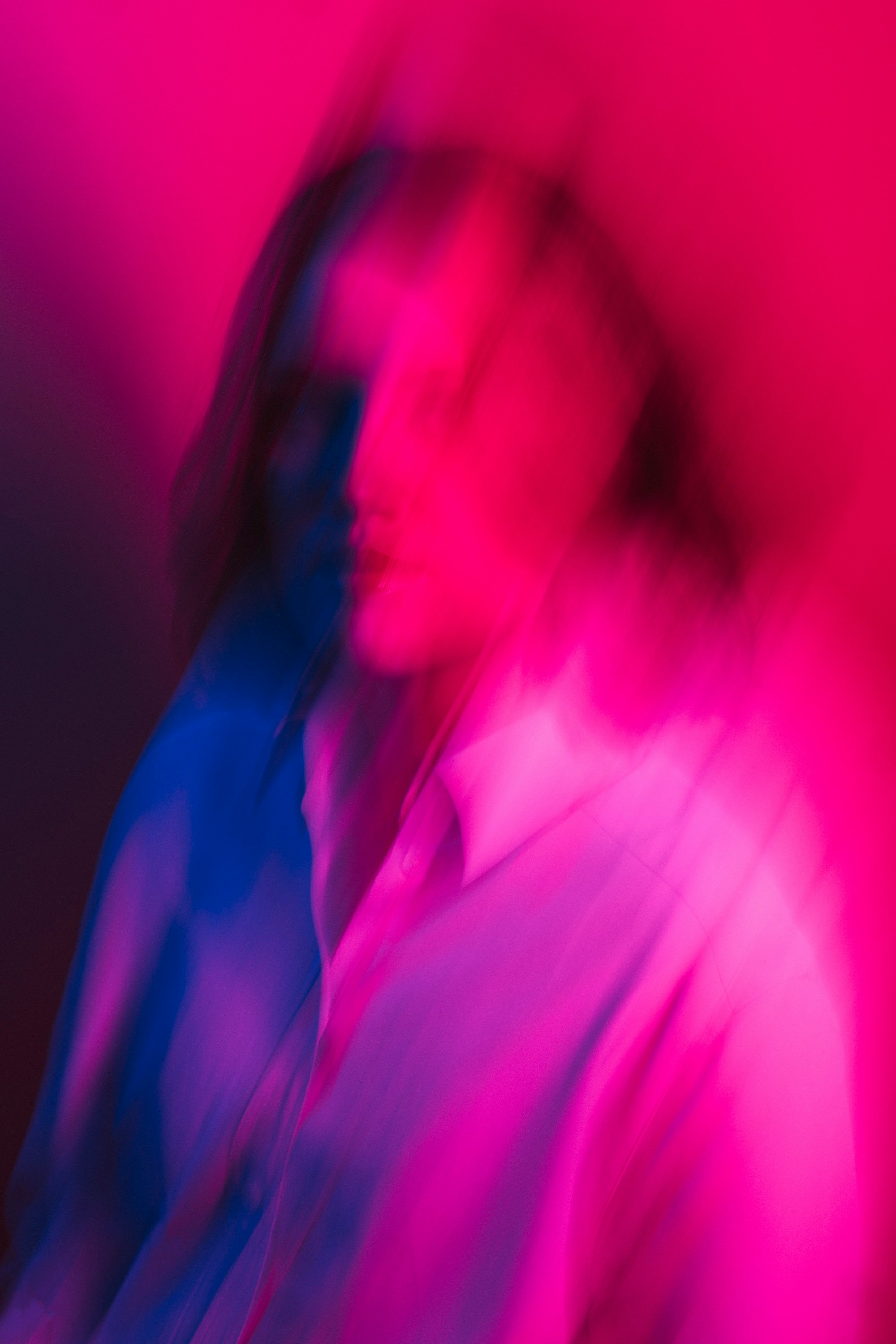 A figure blurred in magenta light