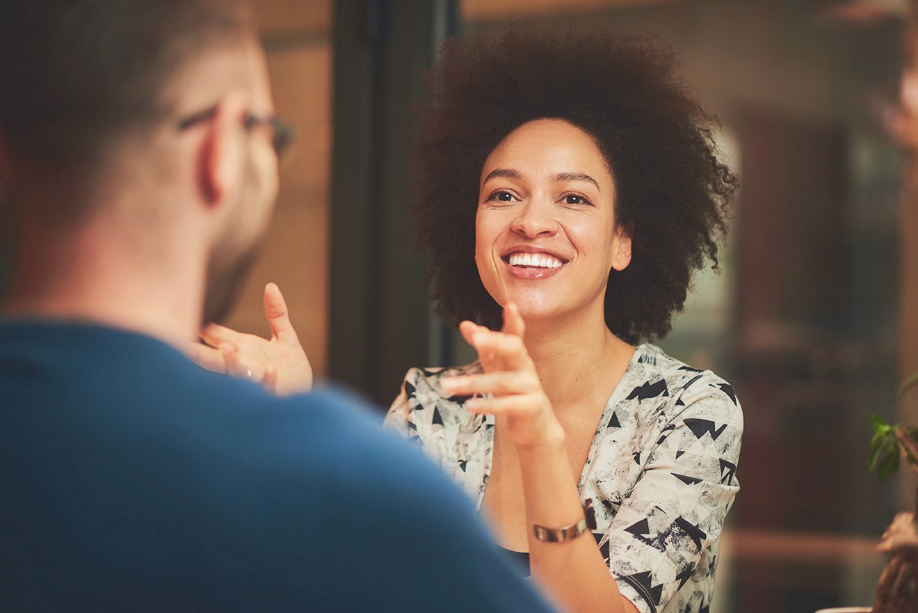 Smiling woman talks with a colleague at the APAP office