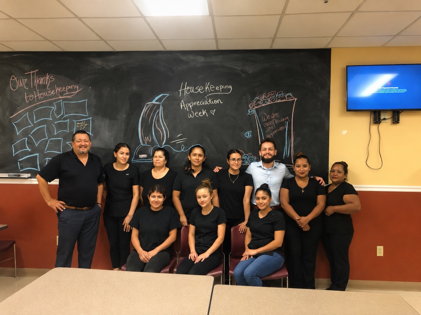 ATI team gathered around a chalkboard of appreciation notes