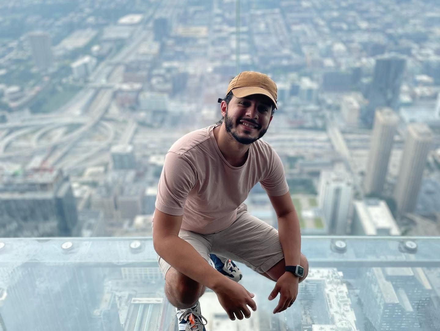 Man with short dark hair wearing a light green shirt, sitting near a window in soft light