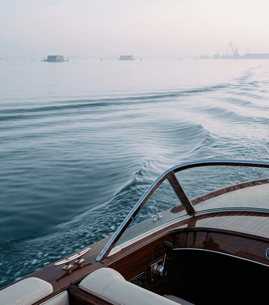 wooden boat on calm Venice water, early morning light, quiet lagoon
