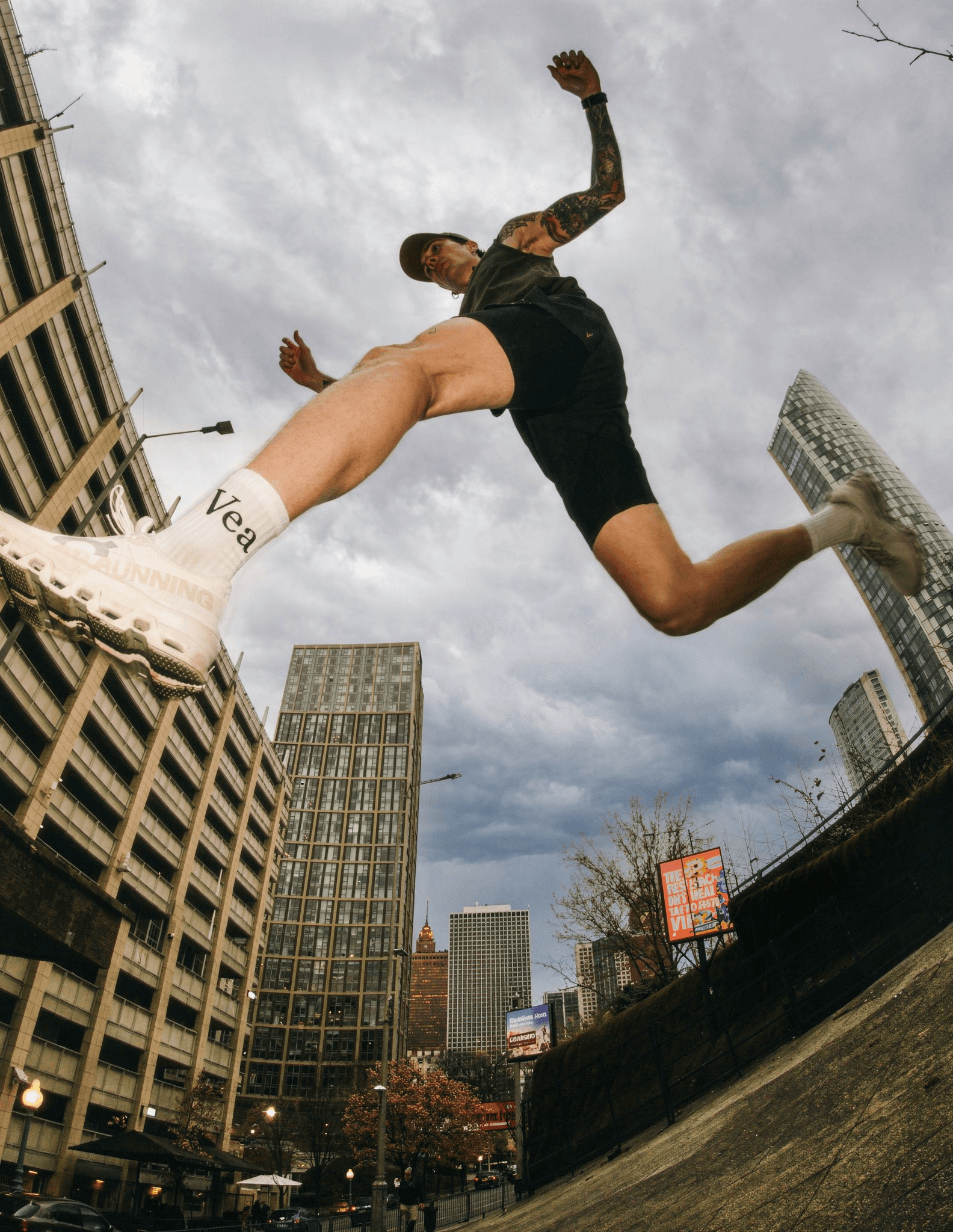Athletic man jumping in urban cityscape wearing Vea branded socks