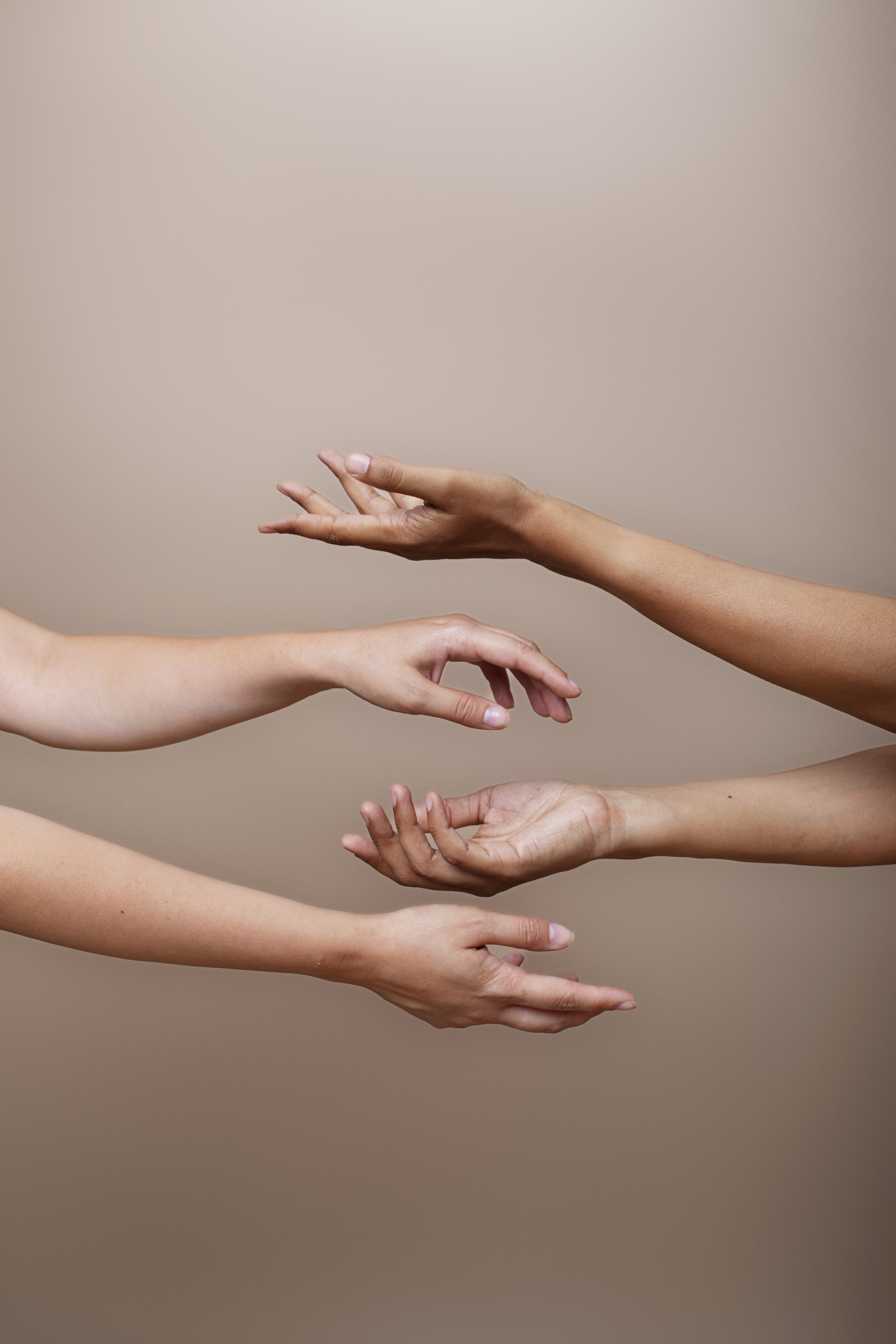 Vrouw die zich deels verschuilt achter een beige gordijn, symbool voor kwetsbaarheid en stilte rondom hormonale klachten